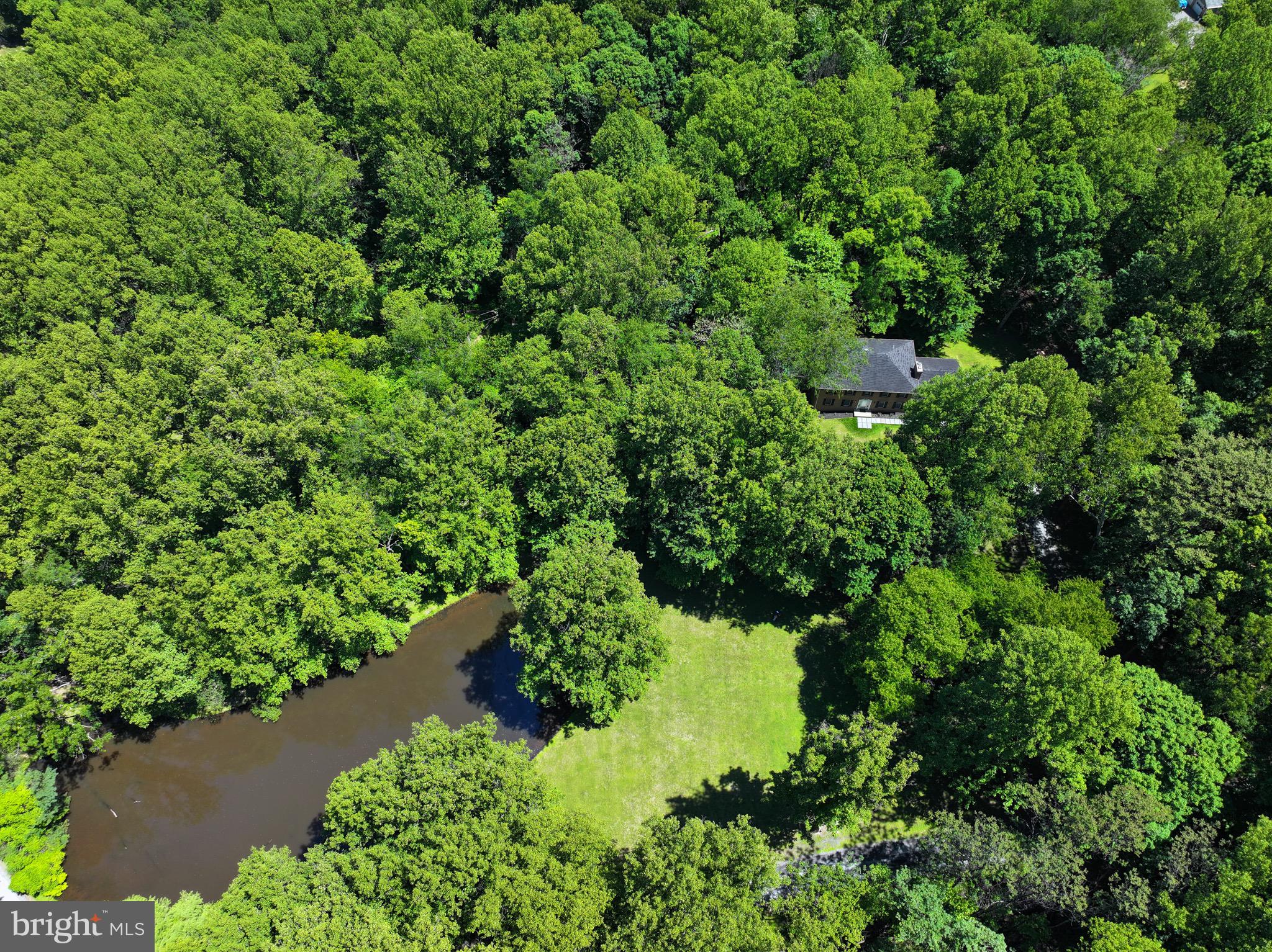 Rare opportunity to own nearly 10 wooded private acres  in Leesburg, featuring five natural streams that feed into a picturesque 2/3-acre stocked pond. Tucked away among mature trees and abundant wildlife, this remarkable property offers the peaceful feeling of a private treehouse retreat while still being conveniently located near everyday amenities.
This all-brick Colonial home  (brick on all four sides) with 2-car side-load garage, offers timeless appeal and exceptional privacy. Situated at the top of a gentle incline, the home is perfectly positioned to capture beautiful wooded views from every direction. A large hardwood deck directly off the kitchen, overlooks the tranquil landscape, creating the perfect setting for relaxing, entertaining and enjoying the of sights and sounds of nature.
The property offers endless possibilities for outdoor living, recreation, horses, chickens, gardening, or creating your own private countryside retreat. Inside, the home immediately feels warm and welcoming, with fresh paint throughout, hardwood floors, and brand-new carpet.  The main level has the family room with a wood burning fireplace and the living room and dining room have views of the stocked pond, kitchen, breakfast area, laundry room with newer washer/dryer and powder room.  The spacious layout includes 4 large bedrooms and 2.5 bathrooms, blending comfort, functionality and scenic surroundings.   The Primary Suite has a wood burning fireplace, walk-in closet and primary bathroom. 
Adding to the property’s charm and history is the small 1861 structure known as “Lucus’ Cabin,” offering a unique glimpse into the area’s past and making this property truly one of a kind.  Lower Level is ready for your finishing touches with 2 windows and walk-OUT sliding glass doors and a rough-in for a future 3rd Full bathroom and 5 bedroom. 

Enjoy the serenity of country living without sacrificing convenience. Close to commuting routes, this exceptional property offers the perfect blend of privacy, nature, history and accessibility.   Just minutes from wineries, breweries, shopping, restaurants and entertainment.