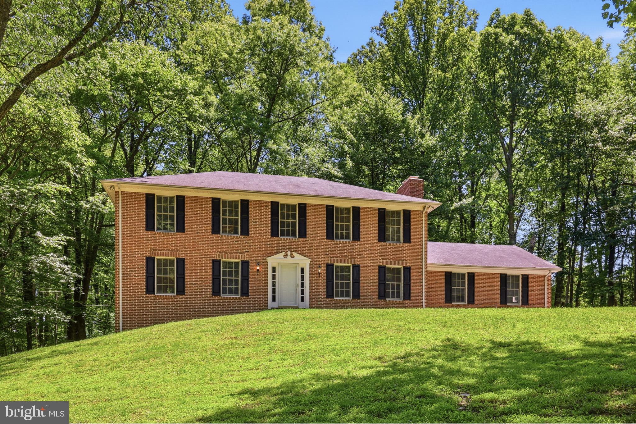 Open house Sunday, July 5- NOON -2pm* Rare opportunity to own nearly 10 wooded private acres  in Leesburg, featuring five natural streams that feed into a picturesque 2/3-acre stocked pond. Tucked away among mature trees and abundant wildlife, this remarkable property offers the peaceful feeling of a private treehouse retreat while still being conveniently located near everyday amenities.
This all-brick Colonial home  (brick on all four sides) with 2-car side-load garage, offers timeless appeal and exceptional privacy. Situated at the top of a gentle incline, the home is perfectly positioned to capture beautiful wooded views from every direction. A large hardwood deck directly off the kitchen, overlooks the tranquil landscape, creating the perfect setting for relaxing, entertaining and enjoying the of sights and sounds of nature.
The property offers endless possibilities for outdoor living, recreation, horses, chickens, gardening, or creating your own private countryside retreat. Inside, the home immediately feels warm and welcoming, with fresh paint throughout, hardwood floors, and brand-new carpet.  The main level has the family room with a wood burning fireplace and the living room and dining room have views of the stocked pond, kitchen, breakfast area, laundry room with newer washer/dryer and powder room.  The spacious layout includes 4 large bedrooms and 2.5 bathrooms, blending comfort, functionality and scenic surroundings.   The Primary Suite has a wood burning fireplace, walk-in closet and primary bathroom. 
Adding to the property’s charm and history is the small 1861 structure known as “Lucus’ Cabin,” offering a unique glimpse into the area’s past and making this property truly one of a kind.  Lower Level is ready for your finishing touches with 2 windows and walk-OUT sliding glass doors and a rough-in for a future 3rd Full bathroom and 5 bedroom. 

Enjoy the serenity of country living without sacrificing convenience. Close to commuting routes, this exceptional property offers the perfect blend of privacy, nature, history and accessibility.   Just minutes from wineries, breweries, shopping, restaurants and entertainment.