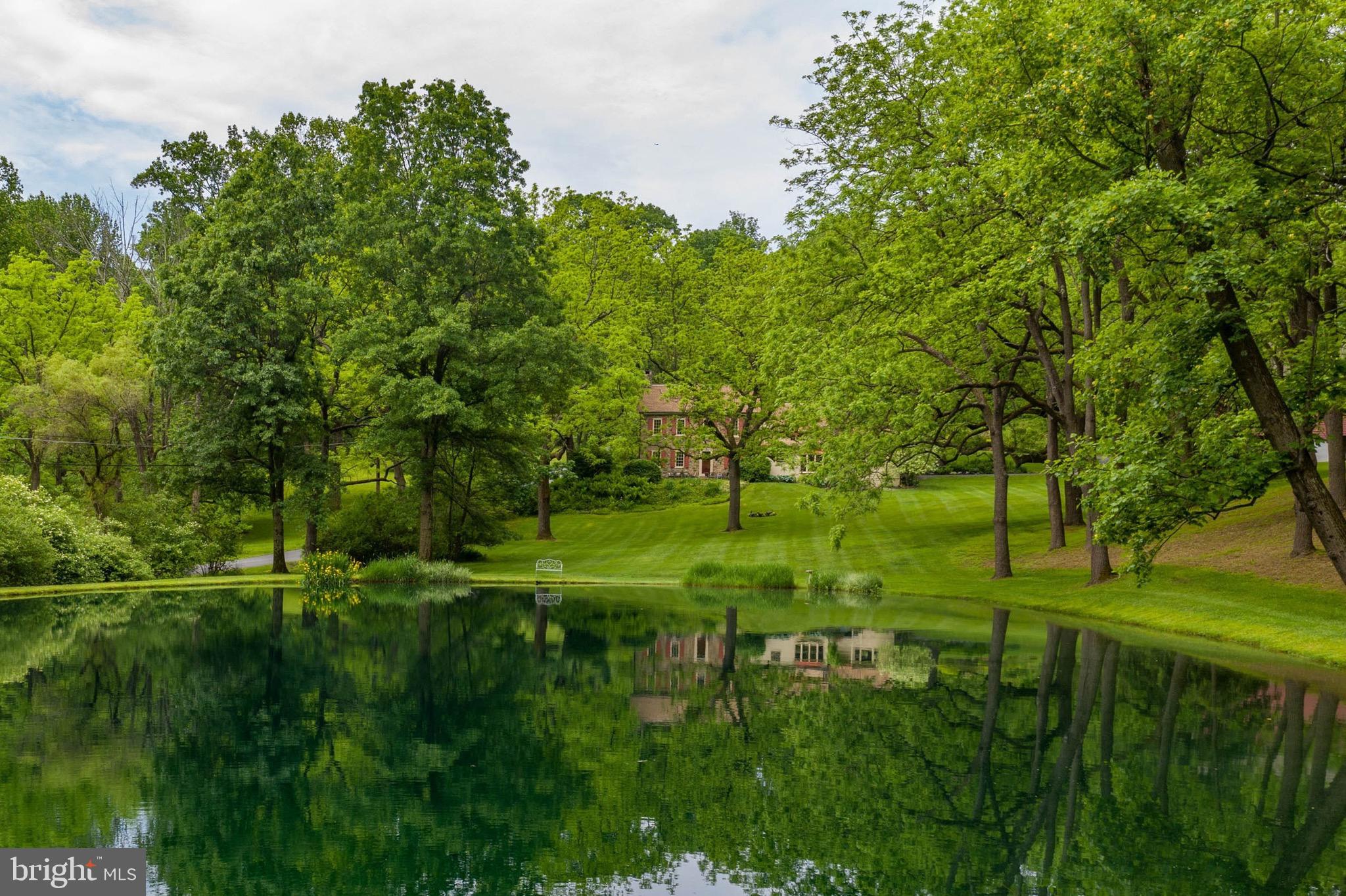 A picturesque spring fed pond, pool, rolling lawns, 25 Acres and surrounding fields and forest set the stage for a country life, uncluttered by the outside world.  At once both a stately gentleman's farm and relaxed Bucks County Stone Colonial, the Hessian House does double duty for those dreaming of a place to make fond family memories, where idyllic gatherings take place all year long. Gardens and rock walls are an inviting entry, drawing visitors to remember the old world sensibilities of yesterday.  At first glance, the Hessian House presents an inimitable richness and authenticity that stands today as a tribute to the skilled artisans of the early 1800's, balancing scale with refined and rich materials.  Hand-hewn beamed ceilings, 4 richly paneled fireplaces, wide board floors, deep set mullioned windows and antique cupboards have been lovingly restored.  A fully renovated kitchen, a dramatic master suite with fireplace and luscious bath, a cathedral-ceiling family room, adjacent keeping room and an 1800's living/dining room with walk in fireplace are just a few of the other amenities. The quintessential stone bank barn houses a large and beautifully appointed studio with full bath - perfect for the weekend guest. Nearby, nestled amidst flowering gardens, is a heated pool with privileged vistas of the 25 country acres.  On the hillside, beyond the barn, sits a 2 bedroom caretaker's home. Minutes from the Lehigh Valley, under 60 minutes from Philadelphia and 90 minutes from NYC.