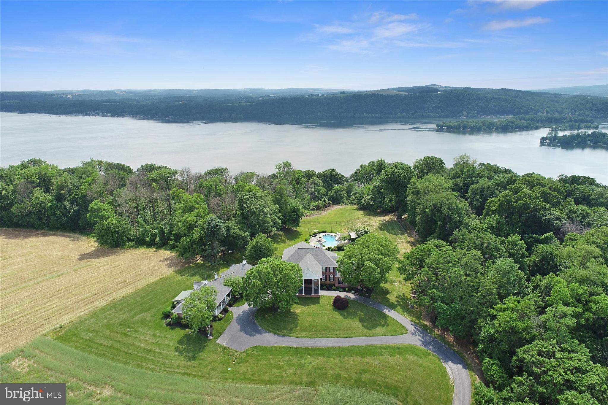 With breathtaking views of the Susquehanna River, this unique and secluded ten-acre estate in Manor Township, Lancaster County, boasts a main residence with nearly 8,000 square feet of living space and a separate three bedroom, two and a half bath home for guests or family members of every generation. Bordered by farmland and wooded areas, the property provides peace and tranquility yet you’re close to major highways and within 15 minutes of downtown Lancaster. A private driveway leads to a stately portico on the main house. Inside the four bedroom, five and a half bath custom home there are fine features throughout. The tiled two-story entry is inviting with a designer chandelier and an elegant double wood staircase. With an impressive stone fireplace, the large great room that opens to a patio makes for grand entertaining. Highlighting the formal dining room is a beautiful hand painted mural displaying the four seasons of the year. To be appreciated is the chef’s kitchen with a breakfast nook that opens to the large back deck. Completing the main house is a finished daylight lower level featuring a movie theater with sloped seating for 12, billiards room, kitchenette, snack bar, gym area, full bath, and the ability to add a steam room and sauna. The guest house offers an ideal spot for guests or family members and includes nearly 2,500 square feet with two bedrooms and two baths on the main floor and an additional bedroom and half bath on the second floor. Connecting the oversized six-car garage to the main house is a breezeway patio with built-in grill that can be used throughout the year. The exterior of this amazing property also hosts numerous other amenities, including an Anthony & Sylvan saltwater in-ground pool, pool house with dressing area and shower, a greenhouse, lower-level patio, and upper-level patio with fire pit and hot tub overlooking the pool area. Don’t miss the opportunity to see this one of a kind estate for yourself. Call today for a private showing!