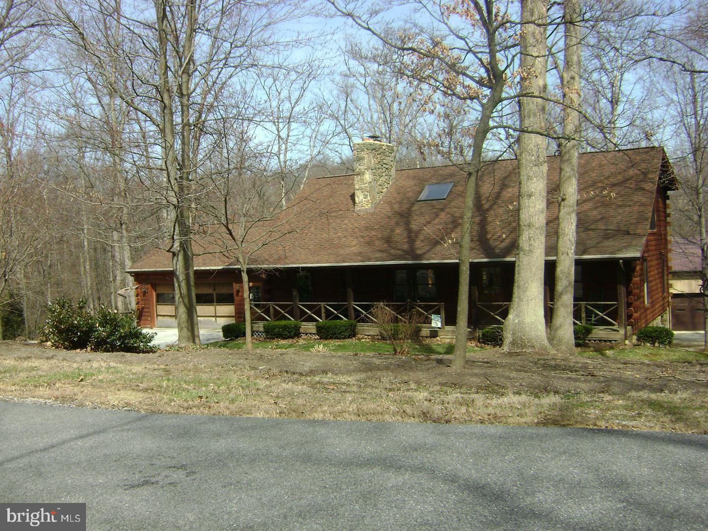 This spectacular custom built log home on 1 acre looks like the day it was built.  Great care is evident inside and outside the residence, which features vaulted ceilings with newer skylights with custom remote operated shades, a REAL floor to vaulted ceiling field stone wood burning fireplace, 3 full baths and first floor laundry. First floor has 2 bedrooms and second floor offers 1 bedroom plus open bonus room / loft which could easily convert to 4th bedroom. The fantastic finished walk-out lower level features a wood stove and has French doors opening to a beautiful, secluded backyard with large patio & deck nestled in a peaceful natural setting complete with creek passing through the rear of the lot. Other amenities include newer roof & boiler, attached 2 car garage, additional 1-car garage with workshop on basement level, AND huge pole building in rear of property for work or hobbies that was previously used for owner’s lawn care business. Tucked away yet still convenient to MD line, 24, I-83, Shrewsbury & York. A must see!