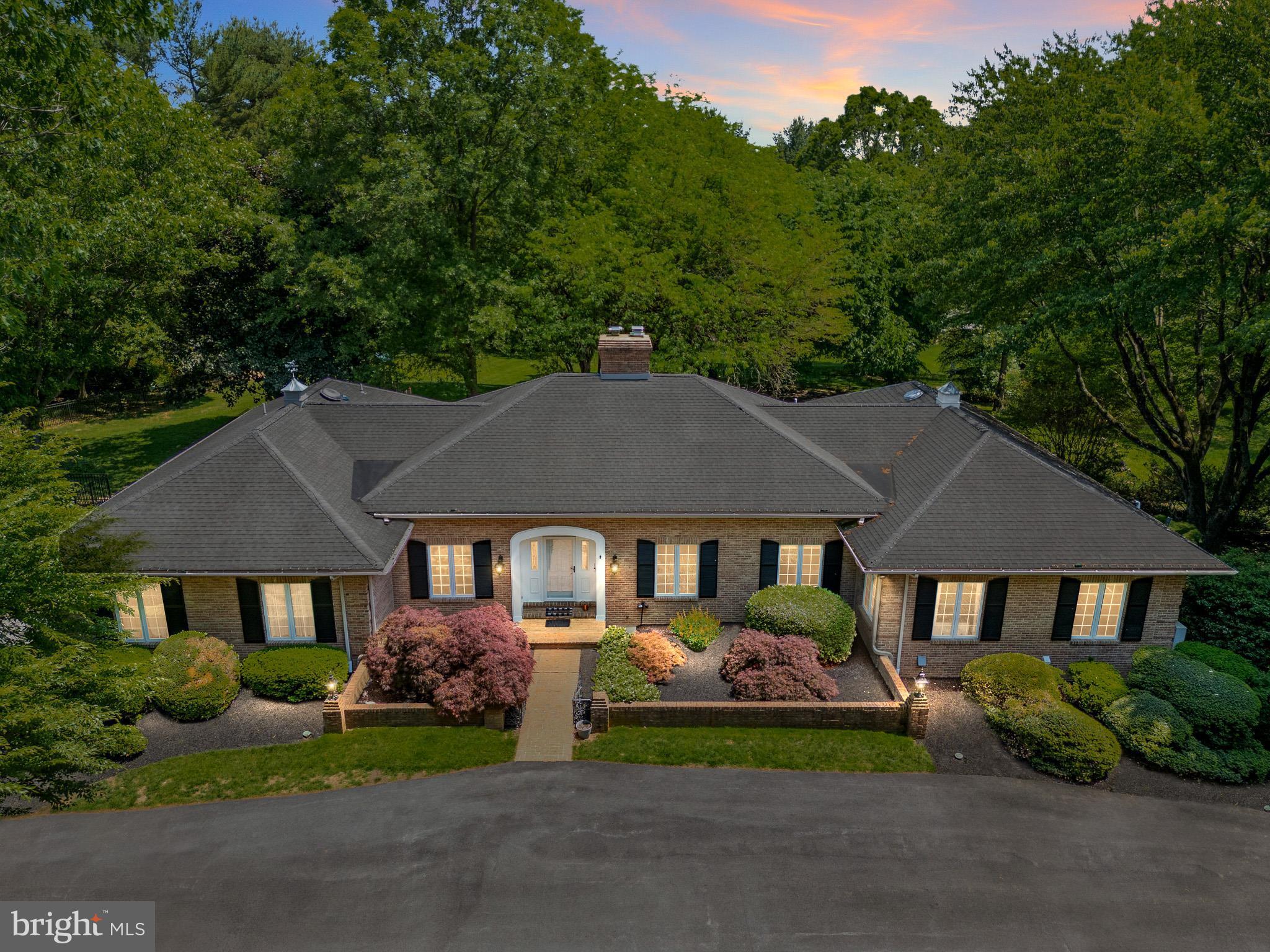 Stunning all-brick custom-built home set on 4.7 private, serene acres in desirable Pennsbury Township within the Unionville-Chadds Ford School District. A long, meandering drive leads to the front entrance and continues to the oversized 2-car garage, creating an impressive sense of arrival. Beautiful landscaping welcomes you to the center hall foyer, flanked by an elegant living room with French doors and a formal dining room ideal for special gatherings. At the heart of the home, the gourmet kitchen features high-end stainless-steel appliances, a large center island, and seamless flow into the family room, where a gas fireplace and a wall of windows frame panoramic views of the property. Just off the kitchen, a spacious mudroom and laundry area with an additional half bath add everyday convenience. The rear hallway opens to a screened-in porch and a New Ipe wood deck spanning the back of the home—perfect for enjoying the peaceful setting. The bedroom wing is privately situated off a long hall from the family room. The primary suite enjoys sweeping rear views, a large walk-in closet, and a beautifully remodeled bath completed in 2021. Two additional bedrooms and a hall bath complete this wing. The lower level offers exceptional versatility, with the potential for a fabulous in-law suite featuring a second primary bedroom, two additional rooms for guest space, a home office, or fitness area, as well as a kitchen and full bath. With a private patio entrance, a Generac whole-house generator, newer systems, and convenient access to Wilmington, Kennett Square, Philadelphia, Maryland, shopping, and dining, this is an incredible opportunity in sought-after Chadds Ford.