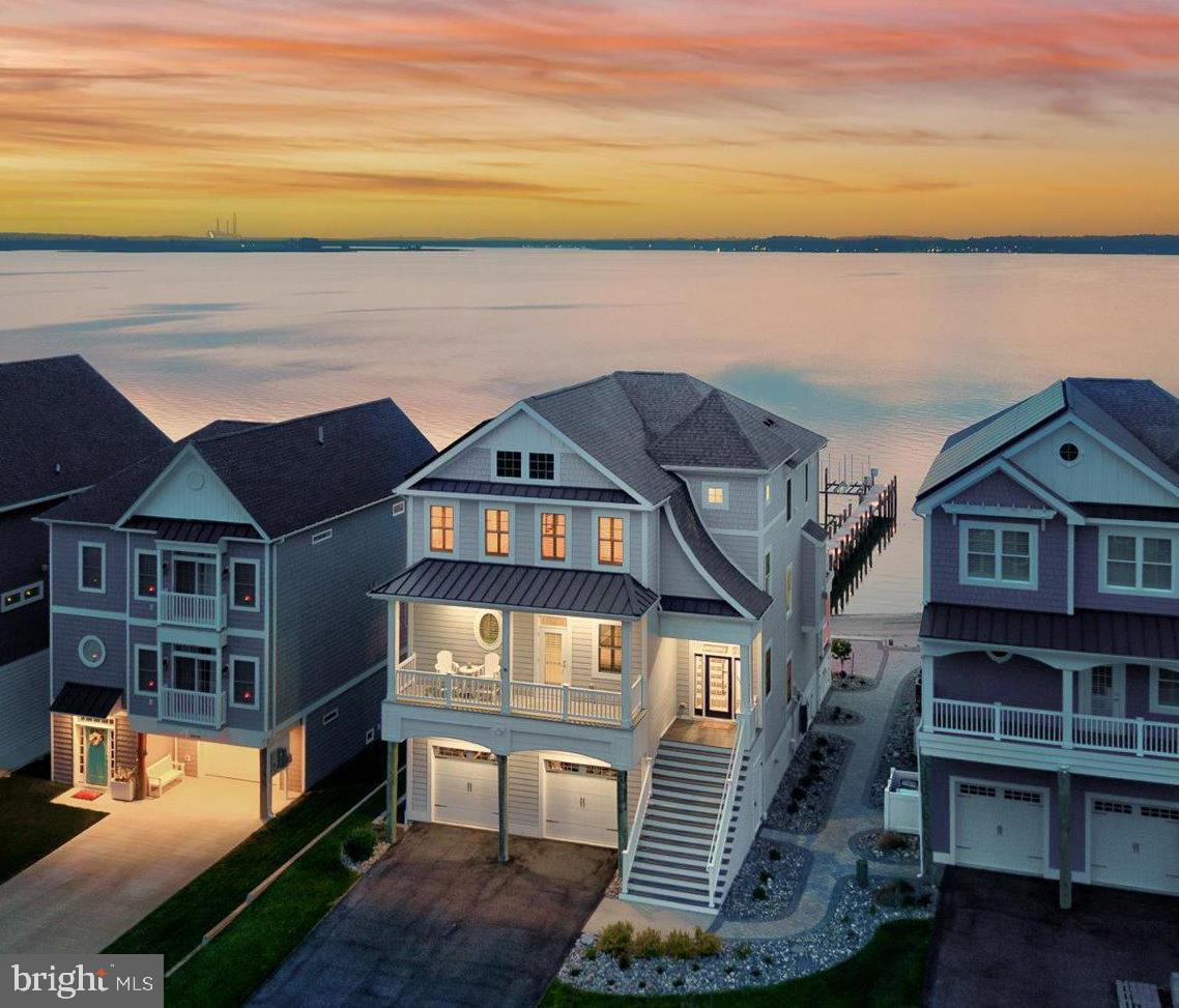 Tucked away on a quiet cul-de-sac, 29710 Seagrass Court is your own slice of bayfront paradise with its own beach and direct water access to the Indian River Bay. Located in Seagrass Plantation, you will experience unmatched panoramic views and an undeniable sense of tranquility. Step inside to sun-drenched spaces and a flowing open floor plan ideal for both entertaining and relaxed living. The chef’s kitchen is a dream—featuring granite countertops, custom cabinetry, and high quality appliances. The luxurious primary suite offers a peaceful escape with a spa-like ensuite bathroom and generous walk-in closet. Additional bedrooms are equally inviting, offering ample space for family, guests, or a home office.  Upgraded window treatments are installed throughout including plantation shutters in all of the bedrooms. The main living area is adorned with Hunter Douglas power blinds that are controlled via remote or app on your smartphone! This energy efficient 4 bedroom, 3.5 bath home also features owned solar panels to keep electric bills at a minimum and a newly installed HVAC with Bosch heat pumps and air conditioning controlled with Honeywell smart thermostats. With an open and functional floor plan, rare west orientation to capture the breathtaking sunsets, over 900 square feet of decks, this gem was built and designed for the ultimate living experience. The original design of the home included an elevator, however the shafts, while still viable for converting back to its intended use and wired for a future elevator, were converted to three large closets to be utilized for additional storage. Moving outside to highlight the grandeur of the exterior, you will be impressed with the thoughtfulness and detail put into every improvement. The lower deck includes a four person traditional Scandinavian sauna with two tiered bench and glass door providing serene views of the Indian River Bay. The gas grill on the main floor deck includes a propane outlet for your gas grill and the propane fueled firepit on the rear patio is supplied from the main tank for the home, eliminating the need for any portable tanks! The dock includes fresh water supply, an electrical outlet, ambience lighting the full length of the 140 ft pier, and an 8000lb Magnum four piling boat lift. Located in a professional manicured neighborhood, Seagrass Plantation offers a large pool, clubhouse and fitness room, pavilion, tennis courts, private beach, community pier and water access for kayaking, canoeing, and paddle boarding. Golfer?  Cripple Creek Golf & Country Club, a beautiful 18 hole golf course with tons more amenities, is just 5 minutes away! Whether you're hosting gatherings or simply enjoying the peace and privacy of your surroundings, 29710 Seagrass Court is the perfect place to call home.  Grandfathered flood insurance available!