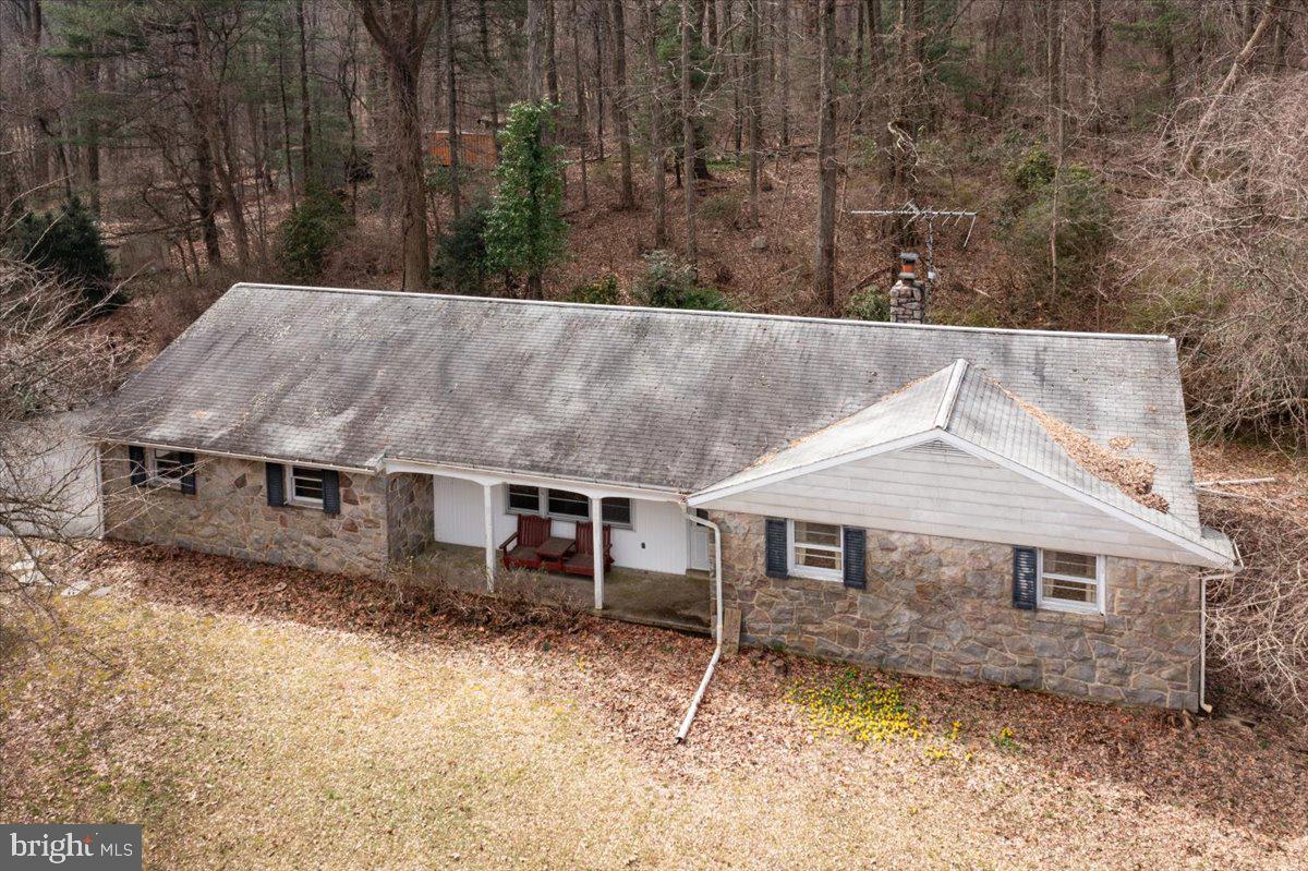 This 3 Bedroom and 1 Bath Stone Rancher was built by Paul Moyer in 1964, it sits on 25+ acres of wooded and pasture property in the Boyertown school district.  The previous owner had horses and there is a horse stable and several outbuildings on the property.  This home has a large living room with hardwood flooring and the kitchen is attached to the dining room that features a stone fireplace with wood insert.  The bedrooms all have large closets and hardwood flooring.  There is also a large laundry room on the main floor.  The basement is unfinished but could easily be finished and there is a workshop area as well.  There is 200-amp electric service, electric baseboard heating as well as a wood stove that heats the entire upstairs.  The large 2 car garage has plenty of room for storage as well as a walkup attic for storage.   There is a front porch with a beautiful view and rear patio to relax and entertain guests.  The home has incredible potential but needs updating throughout the home as well as exterior.  Home is not in Act 319, clean and green.  Located in Earl township, the trash is paid for by the township.  Great opportunity for someone who wants to own 25+ acres, great hunting land, horses or animals could all be managed on this property.