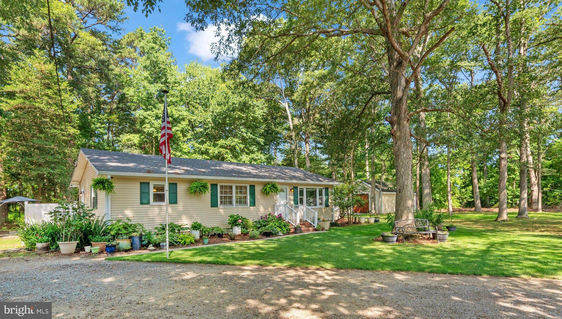 Welcome to 5116 Ocean Gateway, a thoughtfully updated rancher in Trappe offering Eastern Shore charm, comfortable one-level living, 1.5 acres, and an exceptional detached workshop and four-car garage. Conveniently located along Route 50, the property provides easy access to Easton, Cambridge, Oxford, St. Michaels, shopping, dining, waterfront destinations, and everyday conveniences, with Ocean City approximately one hour away. From the moment you arrive, the property makes a memorable impression with its established perennial gardens, expansive landscape, flagpole, security doors, new windows installed in 2022, and a brand-new roof completed in 2026. A 12-by-24 hobby shed with an upper storage level provides even more room for lawn equipment, seasonal items, projects, or recreational gear. Inside, a brand-new, fully insulated 225-square-foot sunroom completed in 2026 expands the home’s living space and creates a bright, inviting place to relax, entertain, or enjoy views of the surrounding property throughout the year. A new whole-house split system installed in 2026 provides energy-efficient heating and air conditioning in addition to the home’s existing baseboard heat. The renovated kitchen combines style, character, and everyday functionality with new cabinetry, granite countertops, a farmhouse sink, recessed lighting, a large island with a Boos Block butcher-block countertop, built-in pot filler, range hood, and a brand-new 36-inch Cosmo gas range. A mudroom, pantry, and butler’s pantry add valuable storage and help keep the home organized. The updated bathroom offers a spa-inspired retreat with a soaking tub, dual-sink vanity, built-in shelving, and a spacious walk-in shower with a built-in bench. The standout feature of this property is the hand-built 24-by-36 heated workshop, barn, and four-car garage. Designed for vehicle access, equipment, hobbies, and serious project space, the building features handcrafted 10-by-10 Ipe wood carriage doors, a rear 8-by-7 roll-up garage door, concrete flooring, a water hookup, high-intensity lighting, 120- and 230-volt receptacles, and 120/230-volt electrical service supported by a 60-amp subpanel. The generous layout provides space for multiple vehicles, boat or RV storage, woodworking equipment, tools, recreational gear, or a dedicated creative workspace. With major improvements, flexible storage, an updated one-level home, a beautiful new sunroom, and a substantial four-car garage and workshop, this unique Trappe property offers a rare combination of comfort, land, character, and utility. Schedule your private tour and experience everything 5116 Ocean Gateway has to offer.