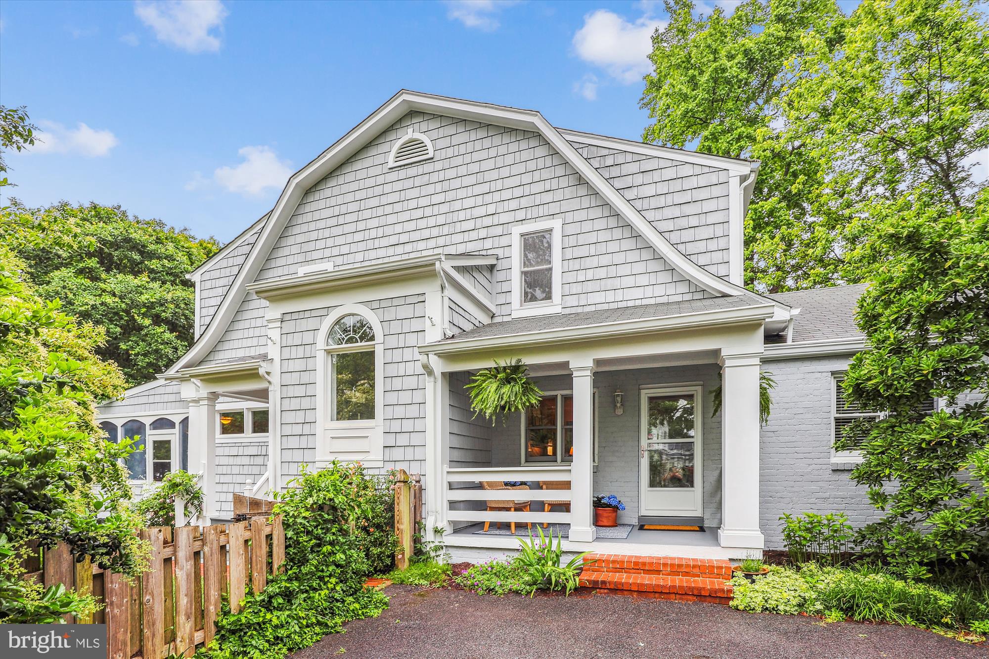 Known as the “Nantucket House” due to its gray, cedar shake shingles, scooping rooflines, and mature always-in-bloom landscaping, this one-of-a-kind home offers both space and unparalleled charm.  The nearly quarter acre lot gives children and pets plenty of room to romp with separate gathering areas for family and friends to relax nearby, either in the outdoor seating areas or on the grand porch, exquisitely enclosed with large picture windows overlooking the entire yard.   The porch boasts 16’ natural wood ceilings, country-style ceiling fans, and plenty of space for lounging on an oversized sectional with dining for as many as 18 surrounded by nature and its light.

The open-concept kitchen, breakfast room, and family room form a communal living space and connect to the grand porch through French doors that open wide,  inviting all to flow to and from one space to the other. 

The home’s blend of practicality and charm extends to the two story entryway foyer, entered from one of the home’s three porches. This entrance is naturally lit by a large southern-exposure picture window that highlights the wide, curved stairwell.  There’s plenty of room on the exterior porch, in the entryway, and in the foyer for removing shoes, school backpacks, coats, and hats, which can easily be stored in the deep, tall custom-designed coat closet that adjoins the foyer.

Head upstairs via the bright, window-filled curved staircase to find three of the five bedrooms. At the top of the stairs, you’ll find a landing large enough for a reading nook for family members to enjoy bedtime story time.  The primary bedroom boasts an ensuite bathroom and a large, custom-designed walk-in closet. Two more bedrooms share the hall full bathroom with attached laundry room, so laundry doesn’t have to be carried from one level to another.

Need main floor living for an au pair, in-law suite, or office? Enter from the driveway (which fits five cars), through yet another lovely exterior porch to the library with its own fireplace and the most formal of the three dining spaces’ dining room. Two bedrooms (or offices) and a third full bathroom are on this main level just off the library and dining room.

The finished basement could be a gym or children’s playroom. It has an additional half bath and a storage area with built-in, floor-to-ceiling shelving.

Walk to Alexandria’s first-rate George Mason Elementary School, as well as several fun restaurants and shops, including Reunions Gifts, Whistle Stop Toy & Hobby, Rocket Fizz Candy Store, Great Harvest Bakery, St. Elmo’s Coffee Shop, Rampart’s Tavern, Café Pizzaiola, Fairlington Pizza, and Baskin Robbins.

Only minutes away from the shops and restaurants of Old Town, Del Ray, and Shirlington, it’s also one stoplight to DC and barely ten minutes to Reagan National Airport.

This beautiful home combines charm, spaciousness, and a versatile layout that is bolstered by walkability, privacy, and neighborhood charm.