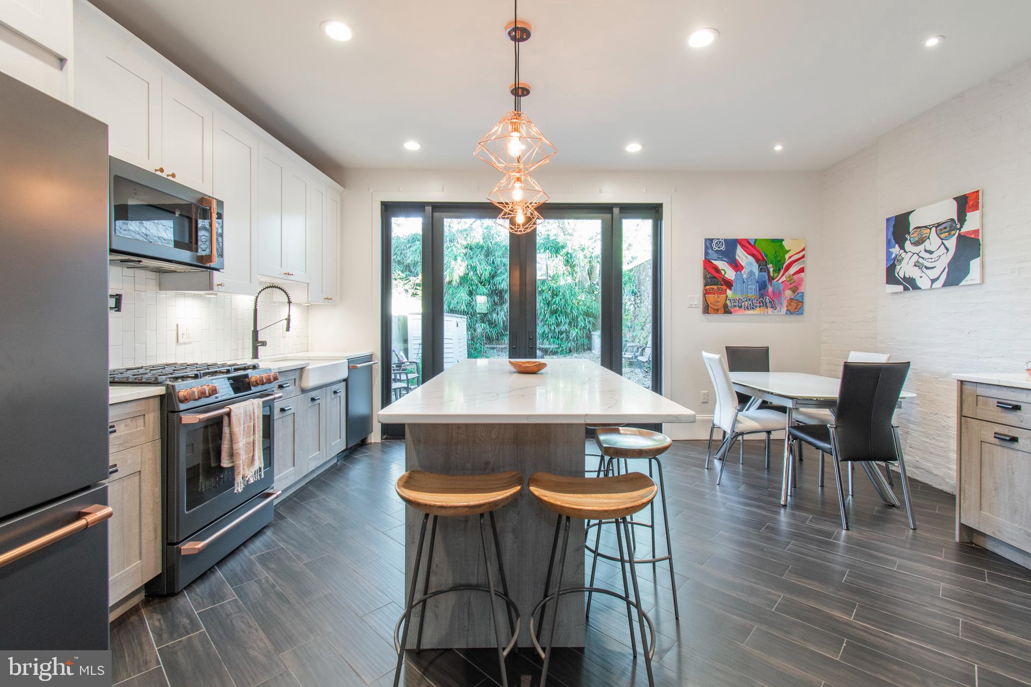 Stunning home in the heart of Fishtown! This extra-wide 4-bedroom, 2.5-bath residence offers an ideal blend of character, modern finishes, and an open-concept layout. The home is filled with natural light, streaming through large front and rear windows and highlighted by custom oversized French doors.

The main living space features a wood-burning fireplace, beautiful flooring throughout the living and dining areas, and an inviting open flow perfect for everyday living or entertaining. The updated kitchen includes a farmhouse sink, GE Café appliances, pot filler, Calacatta Laza quartz countertops, a walk-in pantry, 20+ bottle wine refrigerator, pendant lighting, and striking exposed brick accents.

Just beyond the kitchen, step outside to a huge private backyard—perfect for outdoor entertaining, dining, gardening, or relaxing with friends and family. This rare outdoor space offers plenty of room to create your own urban oasis.

The second floor features two spacious bedrooms, a walk-in closet or ideal home office/Zoom room, and a luxurious marble bathroom complete with a soaking tub, glass-enclosed shower stall, Porcelanosa sinks and faucets, Moen shower fixtures, and a large rain shower head.

The third floor offers two additional bedrooms, one with built-in bookshelves, along with a full bathroom featuring dual matte white Porcelanosa sinks.

Additional highlights include a one-year home warranty provided by the seller. Located within walking distance to the vibrant dining and nightlife of Fishtown, Northern Liberties, and Olde Kensington, this home also offers easy access to public transportation, major highways, dog parks, and more.

Schedule your showing today!
Seller is a licensed Pennsylvania Realtor.