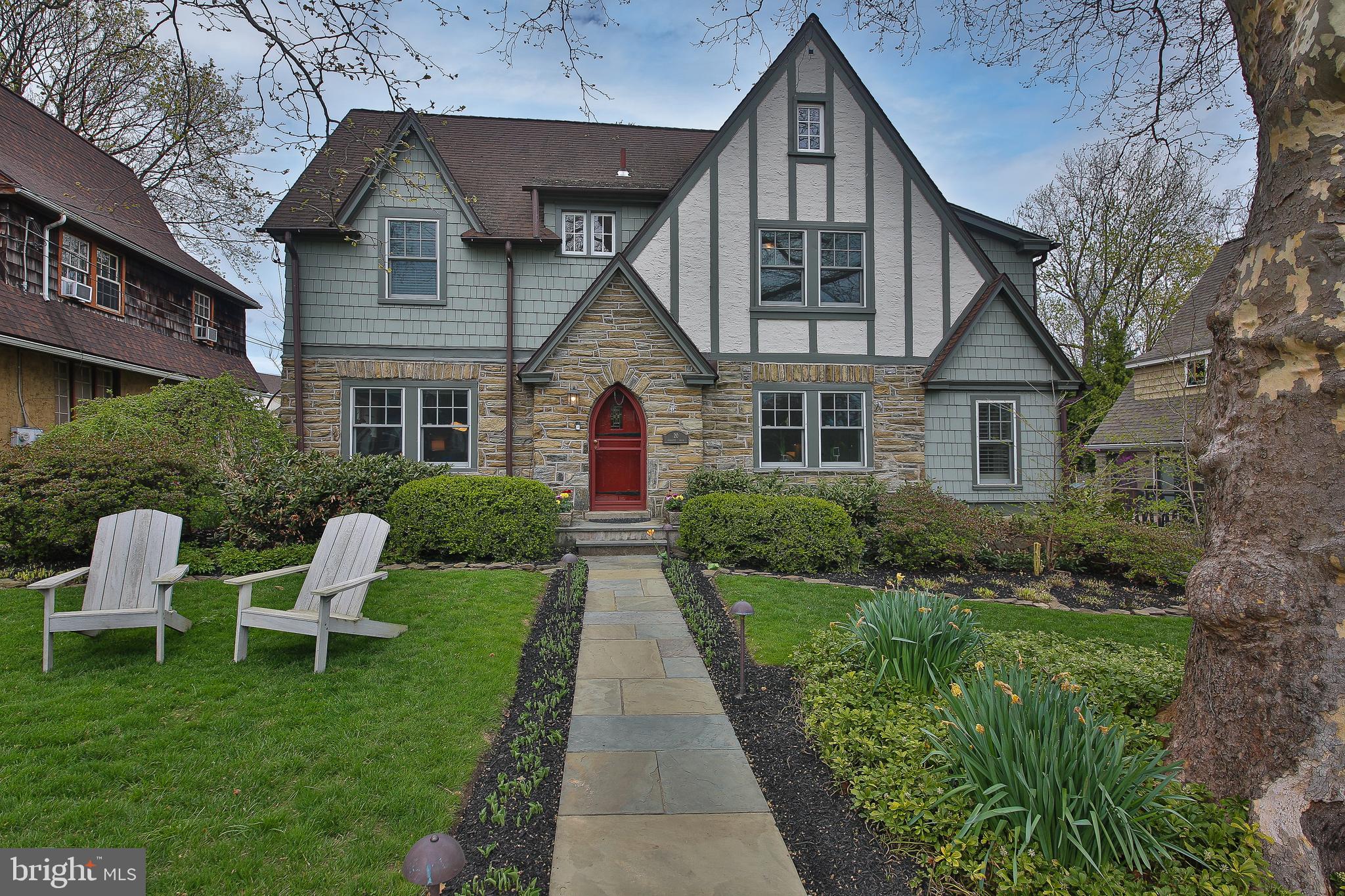 OPEN HOUSE CANCELLED ON 4/18. Walk to Wayne & the train! Welcome to this beautifully renovated stone and cedar Tudor home, blending timeless character with modern comfort in the highly sought-after Deepdale neighborhood.
A charming flagstone walkway leads to the original front entry, opening into a warm center hall foyer, from which you will see the inlaid hardwood floors and impressive millwork. The formal living room features custom built-ins, a gas fireplace with a stone surround and detailed mantle, and access to a bright sunroom highlighted by an exposed stone wall. The formal dining room sits across the foyer.
The gourmet kitchen features white cabinetry, granite countertops, a farmhouse sink, subway tile backsplash, and a center island with seating. It flows to a cozy breakfast area with vaulted ceilings, skylights, and a large window overlooking the lush rear yard. The spacious family room offers a vaulted ceiling, gas fireplace, heated travertine flooring, and French doors leading to the expansive composite deck—perfect for gatherings and seamless indoor-outdoor living. A convenient powder room completes this level.
The current owners thoughtfully reconfigured and updated the 2nd level to create a primary bedroom with custom built-in closets and a luxurious ensuite bath. The bath features a natural wood dual-sink vanity, walk-in shower with bench, clawfoot soaking tub and herring bone tiled, radiant-heated floors. There are two additional sun-filled bedrooms that share a newly-installed Jack-n-Jill bath, which also has radiant floors and a separate water closet. The third floor provides two more bedrooms;  the one that sits behind the “secret bookshelf” has built-in storage, and the other has a private ensuite bath with tiled shower.
Outside, the deck overlooks landscaped grounds with accent lighting, fencing, a custom-built treehouse, a garden shed, and a stacked stone retaining wall. The detached 2-car garage provides easy parking and storage.
Extensive updates include a renovated 2nd floor, full exterior wood repair and painting, complete interior painting, newer central air conditioning unit and hot water heater, added recessed lighting, and newer windows. Radiant heated tile floors enhance comfort in the family room and full bathrooms.
Walkable to Wayne, this home offers easy access to the Strafford train station, shopping, dining, and major commuter routes, with convenient travel to Center City Philadelphia. Pack your bags and enjoy Main Line luxury at its finest!