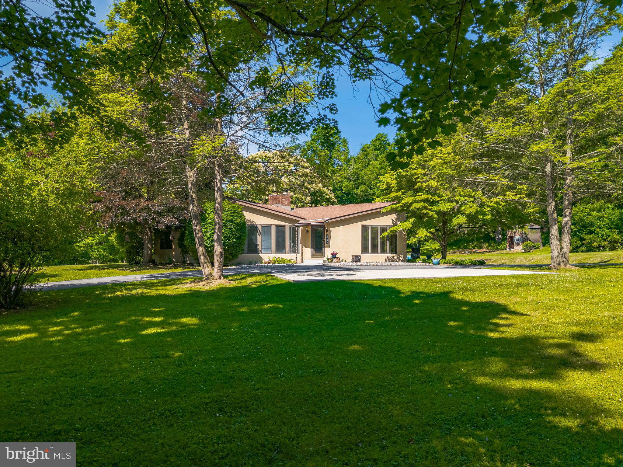 Framed by a lush expanse of lawn and set back from the road, this charming contemporary ranch home stands on a generous 1.4 acres in the Southern Lehigh School District of Upper Saucon Township.
     Mid-century built, this spacious first floor plan, with expansive floor to ceiling windows, integrates indoor and outdoor spaces. The wood burning fireplace is the focal point of a sophisticated living room with vaulted ceiling and exposed beams. The updated eat-in kitchen boasts Brazilian hardwood flooring, Rainforest Green granite countertops, and stainless appliances, with sliding doors to the oversized side deck. Plush carpeting graces the primary bedroom, while the en suite bath includes a fabulous glass vessel sink with waterfall faucet. Two additional generously sized wood floored bedrooms, a hall bath, and a laundry room complete the first floor. The expansive, fully finished lower level includes space for an office, exercise room, media room and hobbies, as well as a full bath and room for storage. Outside, the detached garage has three bays and second story loft storage. 
     The quiet and picturesque neighborhood offers easy access to shopping, restaurants, and community parks. Hospital campuses and thriving businesses in the Lehigh Valley are minutes away via Route 22 and Interstate 78.
