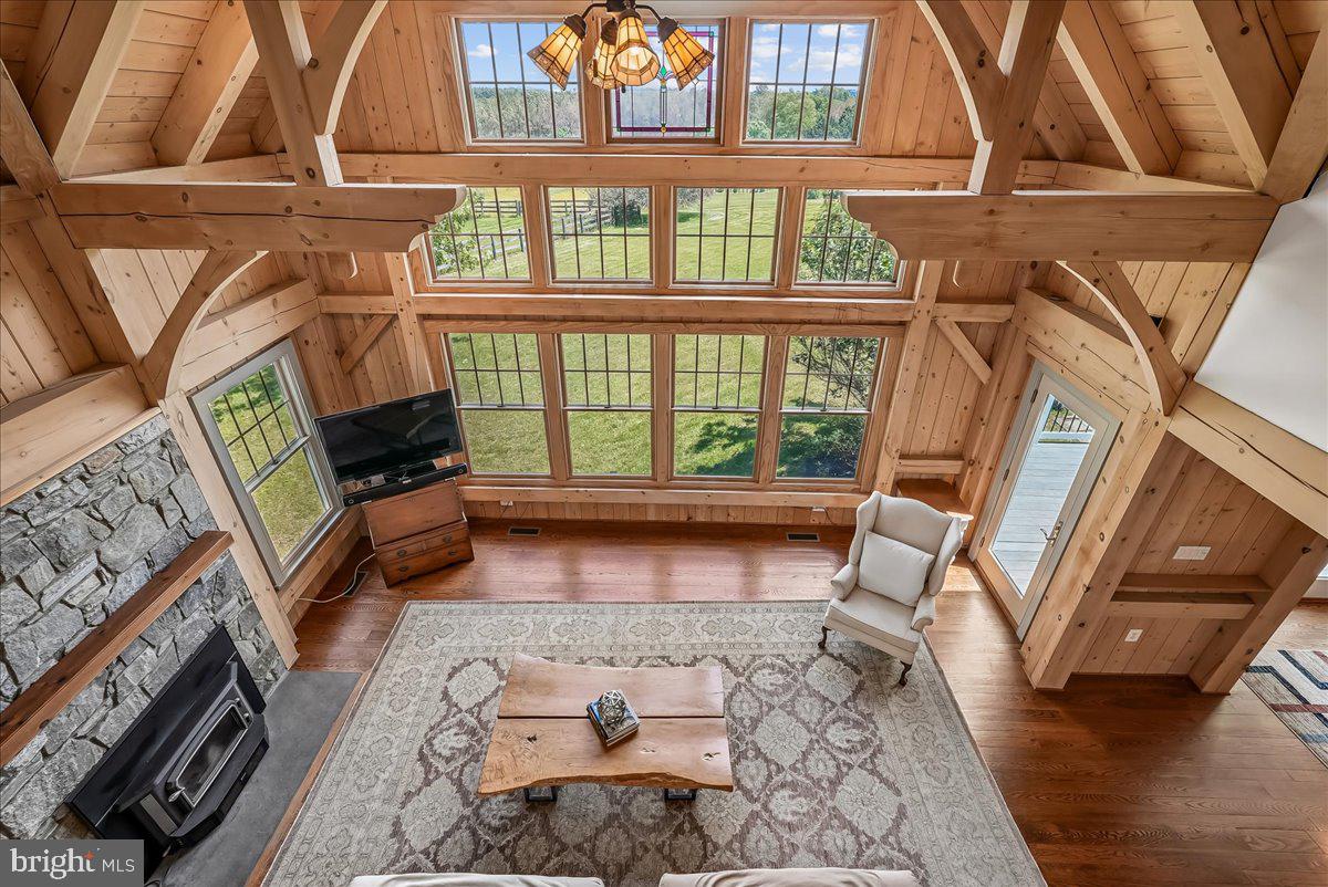 One-of-a-kind Timber Peg frame home custom built by a local builder as his personal residence, blending rustic chalet charm with timeless craftsmanship on a peaceful 1.36-acre homesite backing to nature. Featuring authentic post-and-beam construction with exposed wood walls, soaring ceilings, visible timber framing, and a dramatic wall of windows, this distinctive retreat offers over 3,800 finished sq. ft. of warm lodge-style living space. Spacious main level primary suite with unique Jack & Jill style bath. Four spacious and distinct upper level bedrooms including one with a secret hideaway loft. Enormous upper level bedroom can also be used as a recreation or craft room. Highlights include a stone fireplace, modern farmhouse kitchen, screened morning room, open catwalk upper level, oversized 2.5-car garage, cedar siding, and full walk-out basement.  Located on a prime cul-de-sac. A rare opportunity to own a truly special home filled with character, architectural detail, and natural beauty.