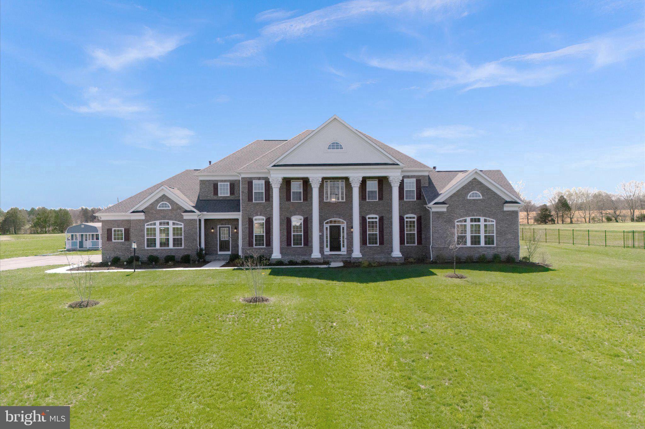 Welcome to Aden Road! This exquisite property, crafted by Augustine Homes, showcases the Stratford III floor plan, offering 5 bedrooms, 6 full bathrooms, and 1 half bath, all thoughtfully designed across over 8,600 square feet of living space on 10 acres of land. Built just two years ago, this stunning property offers ample room to live, work, and entertain—all without the restrictions of an HOA.
As you step inside, you’re greeted by a grand two-story foyer, setting the tone for the spacious, open-concept design that follows. To your right, the inviting sitting room features a double-sided fireplace, seamlessly connecting to a bright, light-filled sunroom. This area includes a full bathroom and a walk-in closet, offering great flexibility to potentially convert it into a main-level bedroom.
Across from the foyer, the formal dining room provides the perfect setting for both intimate family dinners and larger gatherings. A butler’s pantry, with its charming pocket door, leads into the jaw-dropping gourmet kitchen, where elegance and style are on full display, featuring top-of-the-line finishes and exquisite design details. The kitchen showcases an oversized island, elegant light gray cabinetry that extends to the ceiling, and soft-close drawers. You’ll notice under-cabinet lighting, as well as inside the upper glass-door cabinets, creating a warm and inviting glow. High-end appliances, including a GE Tall Tub dishwasher, a 30” convection double wall oven, a 36” Café cooktop, and a 22 CF Café refrigerator, elevate the cooking experience. Brushed gold accents and pristine quartz countertops add the perfect finishing touches to the kitchen's elegant design.
The kitchen opens into both a second sunroom and a spacious great room, featuring a gas fireplace with stunning stonework and a coffered ceiling, creating a cozy space to unwind or entertain. The main level also includes a convenient half bath, a private home office, and a mudroom with access to the three-car garage, which is equipped with a 220V outlet for electric vehicle charging. A separate entrance from the mudroom provides additional ease and accessibility.
Upstairs, you’ll find three generously sized secondary bedrooms, each offering ample closet space. One features an ensuite bathroom, while the other two share a “buddy” bath. The owner’s suite serves as a serene retreat with a tray ceiling, a private sitting area, and an expansive walk-in closet. For added convenience, the laundry room is just steps from the primary closet. The luxurious owner’s bathroom includes dual vanities, a freestanding tub, and a large shower with dual showerheads, offering a spa-like experience for ultimate space to rejuvenate.
The basement is the perfect entertaining space, with a large rec room, game room, and wet bar featuring quartz countertops. A media room invites cozy movie nights, while a legal bedroom and a full bathroom provide extra accommodations. Plus, there's a hookup for a second laundry room for added convenience. A den, second full bath, home gym, and plentiful storage complete the lower level.
Outside, the backyard offers a small deck ready for grilling (complete with a gas line). New trees enhance the landscape, and the whole-house generator ensures peace of mind during any harsh weather. Electrical outlets on the front porch make it easy to decorate for any occasion, whether it’s a holiday or a special celebration. 
Conveniently located with easy access to shops, restaurants, and commuter routes, this home maintains a serene and private setting. Ready to greet its new owner, Aden Road perfectly balances contemporary living with timeless appeal.