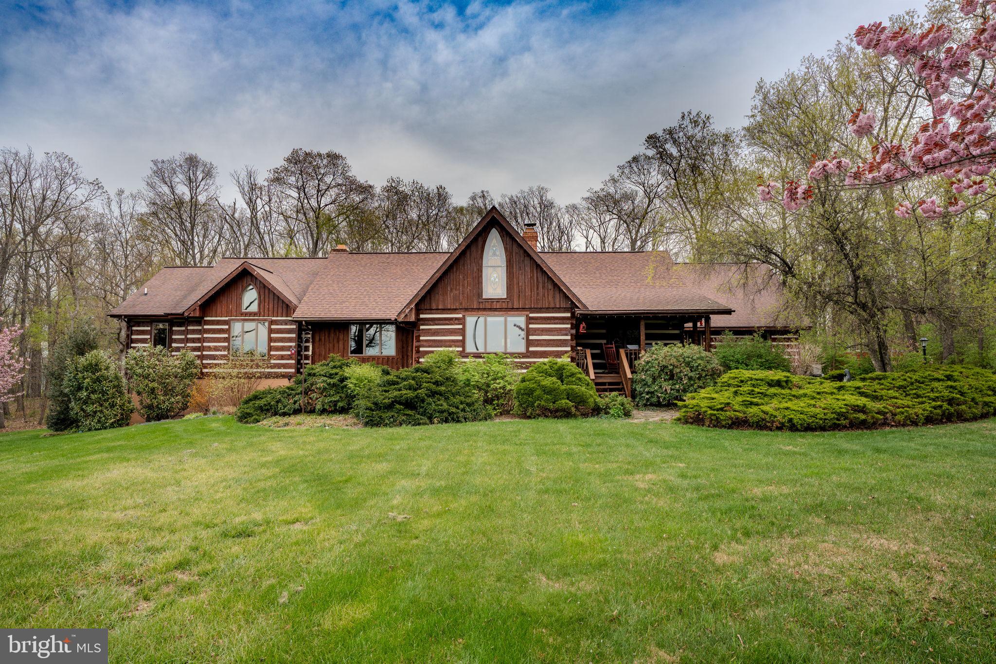Welcome to a truly one of a kind custom home nestled on over 7 private wooded acres in sought-after Sykesville. 🌲🦌 Located at 1720 Charles Ray Acres Drive, this extraordinary estate blends timeless craftsmanship, rich history, and modern comfort across more than 7,200 finished square feet with 6 bedrooms, 4 full baths, multiple garages, resort-style outdoor amenities, and incredible entertaining spaces.

From the moment you arrive via the private half-mile paved circular driveway, you’ll appreciate the attention to detail and character throughout. The home showcases authentic log construction, soaring vaulted and beamed ceilings, oversized Andersen 700 Series picture windows, and stunning architectural elements sourced from historic properties. The stained-glass window in the front room was salvaged from a Pennsylvania church dating back to the 1850s, while the clawfoot tub in the primary suite carries its own historic story and has been beautifully restored with solid brass fixtures.

The heart of the home is designed for gathering and entertaining. The family room features a full masonry oversized fireplace complete with a brick oven, while the main fireplace includes a Hampton wood-burning insert capable of heating the home through radiant heat. Custom Amish crafted features are found throughout, including the entertainment center milled from trees harvested directly from the property, handmade vanities, black walnut cabinetry in the butler’s pantry, custom live-edge mirrors, and built-in closet systems.

The gourmet kitchen is equipped with commercial grade appliances including a Wolf oven, Thermador hood, double refrigerator, Maytag stainless dishwasher, reverse osmosis water system, oversized island, and handcrafted live edge serving station. The adjacent butler’s pantry provides additional prep space, power, and custom cabinetry.

The luxurious primary suite offers a spa-like bath with slate flooring, a restored clawfoot tub, custom Amish-built double vanity, walk-in shower with Schluter system, built-in gun safe, and handcrafted spiral staircase designed by a blacksmith using wood milled from the property. Additional bedrooms include newly carpeted main-level rooms and a renovated loft suite with private bath completed in 2023.

The fully finished walkout lower level provides exceptional additional living and entertaining space featuring a custom bar area 🍻, spacious family room, recreation room, additional bedroom and full bath, plus French doors leading directly to the outdoor entertaining areas.

For the outdoor enthusiast and hunter alike, this property is truly unmatched. 🦌🌲 The private wooded acreage offers exceptional seclusion, established walking trails, a hunting blind/tree stand, abundant wildlife, and the peaceful setting every nature lover dreams of. Whether you enjoy hunting, hiking, ATV riding, target practice, or simply relaxing surrounded by nature, this property delivers the ultimate outdoor lifestyle retreat.

Outside, the property continues to impress with expansive covered porches, beautifully landscaped grounds, walking paths, firepit area 🔥, above-ground pool with electric 🏊, hot tub retreat ♨️, detached 40x30 shop with new lean-to addition, oversized attached garage, detached multi-bay garage space, and abundant parking for guests, hobbies, recreational vehicles, or business needs.

Additional updates and features include:

✨ Four-zone HVAC systems all less than 10 years old
✨ Newer well and pressure tank
✨ Architectural shingle roofs updated in phases including the main house in 2022
✨ French doors to the walkout lower level
✨ Custom iron railings and artisan craftsmanship throughout
✨ 9 garage spaces between attached and detached structures
✨ Peaceful wooded surroundings with exceptional privacy

This is more than a home . It’s a legacy property filled with craftsmanship, history, warmth, adventure, and unforgettable character.