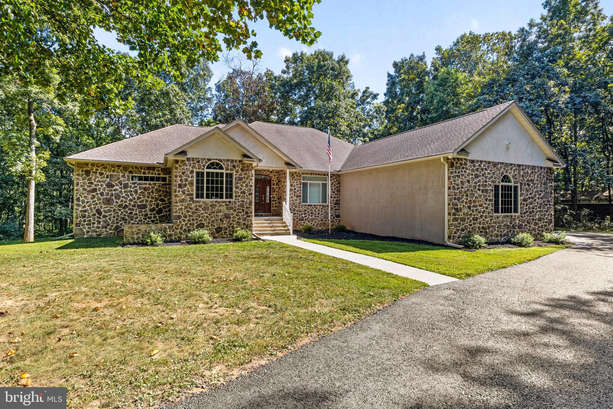 This approximately 3,132 square-foot house features three bedrooms and two and a half bathrooms. The spacious lot offers a charming exterior with lush landscaping and a stone exterior. A spacious garage and paved driveway provide ample parking.

The interior boasts a spacious layout with hardwood flooring throughout, allowing for abundant natural light. The primary bedroom is well-appointed with an expansive, elegant bathroom featuring ample counter space and storage.

The living areas are thoughtfully designed, with a focus on comfort and functionality. The home's expansive deck overlooking the wooded surroundings creates a peaceful, lush environment. The spacious yard and expansive grounds offer a scenic, countryside setting, complete with a covered porch for enjoying the tranquil wooded views.

The property is over 19 acres and is currently in clean and green. Come check out this immaculate home before it sells! The home also has a large 3-car garage. If you want even more garage space, fear not, there is also 2 pole barns!  ONE OF A KIND!