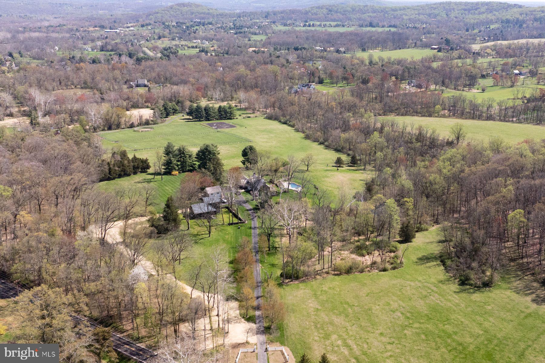 A treelined driveway takes you to a piece of Heaven on 53+ acres of rural beauty with its natural woodland & complementing pasture. Seldom is a property offered enjoying the trappings of a breathtaking location, outstanding supporting real estate, privacy & a residence that is Simply & Stunningly Elegant! Gracious 18th century pointed stone & frame farmhouse is tucked away on one of Upper Makefield Township’s coveted roads of unparalleled open space & enjoys the wonderful company of rolling farmland & fine estate properties. Verdant vistas have not changed much over the last 2 centuries. Warm, inviting & comfortable, this meticulously maintained home looks across sprawling rolling fields, a captivating view of Bowman’s Hill & bucolic countryside in the distance. Quality is a hallmark of this exceptional property. If it’s “all in the details”, you will easily appreciate the many subtle refinements & consistent use of exceptional materials chosen by its owner’s discerning eye, creating balance, relaxed sophistication & a great grasp of aesthetics. Finely milled woodwork & extensive use of solid mahogany floors throughout. Appealing stone, marble, imported wallcoverings, exceptional European lighting & plumbing fixtures capture your senses, providing seamless balance & pleasant surroundings. Enjoy ever-changing seasons offered by the excellent placement of windows. The foyer & its uncommon, raised panel arched doorways welcome you & set the stage for a very pleasant experience. Living room of great proportion w/ its dual graceful staircase & large, mantled fireplace is complimented by captivating hand painted scenes of the Turkish Bosporus waterway. Formal dining rm. w/ cut stone mantled fireplace features raised paneling, subtle gouge woodwork & corner cupboard. Well-planned gourmet kitchen will please the most accomplished chef w/ its large center island. Your eye is drawn to an exposed fieldstone wall, generous raised panel cabinetry & soapstone counters. Appliances include Wolf, Sub-Zero & Bosch. Adjacent pantry w/wet bar offers abundant cabinetry, double prep area & under counter storage. It is conveniently positioned between the dining room & kitchen. Breakfast area w/ wrap around window & French door leads to a flagstone patio & lovely view of the pool and wooded hillside. Family room complimented w/ barrel ceiling & window of sizeable proportion & extensive raised panel cabinetry offers a great space for intimate entertainment. Den/study is perfect place to curl up with a book & relax on a winter’s day. Enclosed screened flagstone porch allows outdoor seasonal dining. Primary bedroom suite w/ mantled fireplace opens onto a rooftop deck. It offers a luxurious marble bath w/ custom oversized shower, dressing area & 2 custom designed walk-in closets w/ organizers. There are 3 additional bright & cheerful bedrooms, plus 2 classic marble & tile baths completing second floor. Third floor offers a spacious bedroom/flex space w/half bath. Wonderfully private setting surrounds heated in-ground pool, set amongst blue stone aprons, walkways & patio areas for soaking in the sun & summer soirees. Charming carriage house offers heated 3 bay garage as well as potential studio space above. Stone & frame barn makes a perfect place for your favorite pets & animals. An impressive list of “top of the line” newly installed materials were chosen. Use of premium wood roof shingles, standing copper roofs, gutters & downspouts add both physical & aesthetic value to this marvelous home. There is a noteworthy high output “Whole House” generator. “State of the art” plumbing, electrical, zoned heating & air conditioning systems are quite impressive! List of exceptional recent improvements & refinements are numerous to mention. A Sensational place for Entertaining, Sharing & Celebrating life! Come see why this Extraordinary Home & Property is one of Bucks County’s finest offerings available!