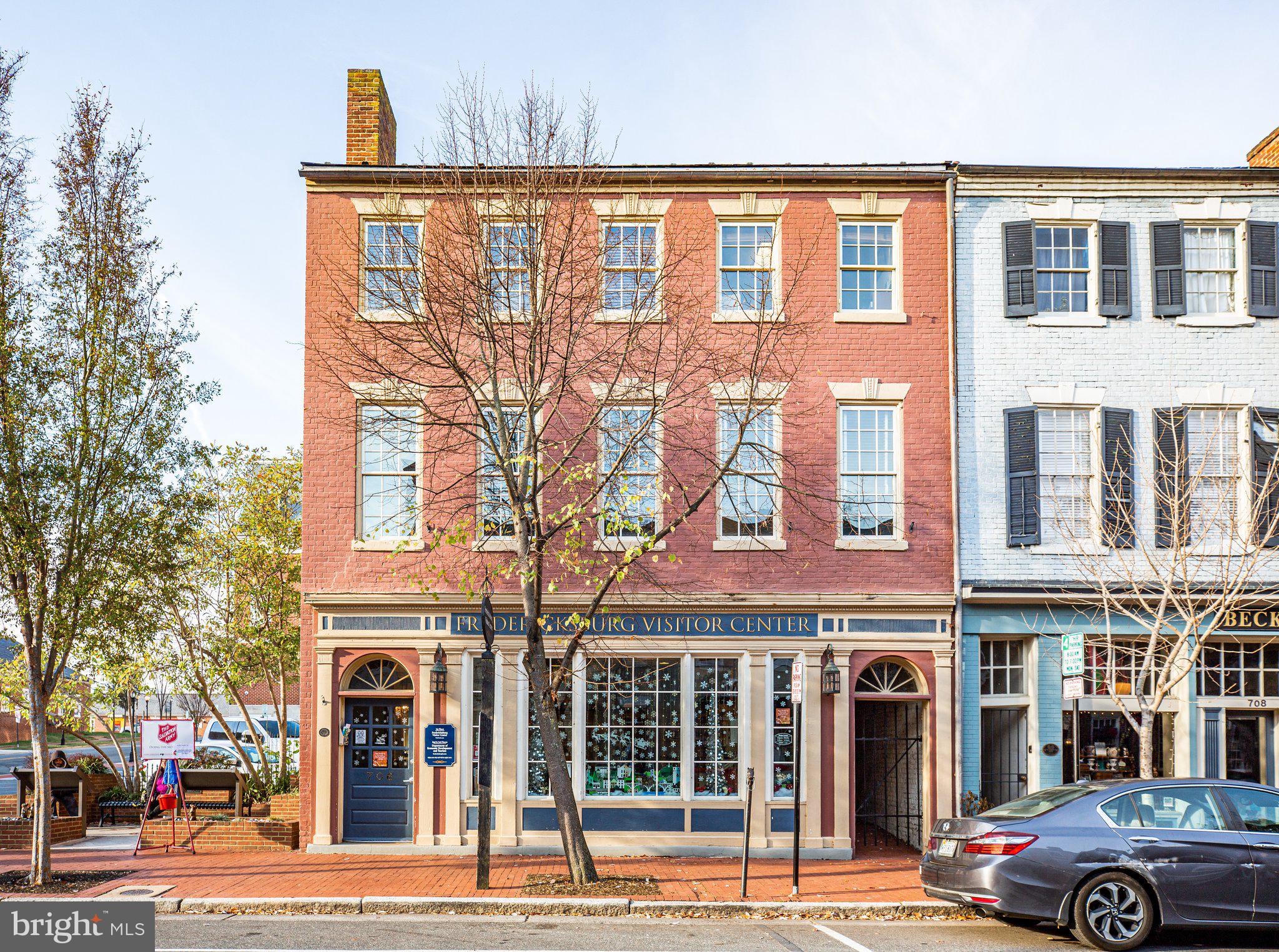 Fredericksburg’s Economic Development Authority (EDA) owns this historic property in the heart of downtown Fredericksburg. It’s within a block of Riverfront Park, the Sophia Street Parking Garage, the Courtyard by Marriott hotel and dozens of restaurants, art studios, and retail  shops. This is truly a one-of-kind opportunity. 
 This sale includes a 5,319 SF building and a 14 space parking lot.  Currently leased by the City of Fredericksburg for The Visitor Center and the Economic Development and Tourism Office for up to 24 months as they build out their new location, this gives the new owner time to plan and get approved any new construction while it is fully leased. 
Built in 1824 and used originally as a confectionary shop and residence, there were extensive renovations done in 1975 and designated as the "Bicentennial Center"! The front of the building consists of three levels with the visitors center on the main floor and two floors of office space above. There is a large meeting room on the main floor and a large storage area. In the back of the building there is a small 2nd floor office space with a 1/2 bath. There are 2 public bathrooms accessible from the exterior only that must remain public during the lease period only.  The 14 space parking lot creates lots of opportunity for creative use of space.