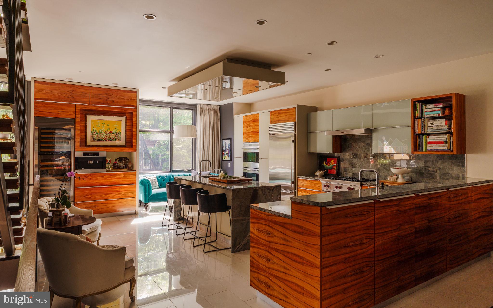Discover the epitome of Center City living in this contemporary four-bedroom elevator townhouse meticulously designed for luxurious living and entertaining. Enjoy five levels of designer interiors, an exceptional gourmet kitchen, spacious bedroom suites, a rooftop deck with dramatic skyline views, and an attached two-car garage — all just three blocks from Logan Square.
Built in 2011, this expansive home delivers exceptional materials and craftsmanship throughout, from the sky-high ceilings dotted with speakers and recessed lighting to the gleaming stone tile and hardwood floors. In between, stunning millwork and floor-to-ceiling windows create a magazine-worthy ambiance throughout.
Arrive on the ground floor where the two-car tandem garage and street-level entry open to a gracious foyer lined in rich floor-to-ceiling paneling and a convenient coat closet. Ahead, you’ll find a spacious home gym, a guest room and a well-appointed bathroom.
Ascend the open wood-and-steel staircase or board your private elevator to arrive at the impressive entertaining level flanked by dramatic floor-to-ceiling windows. Here, the open-plan layout places inviting seating and dining areas around the spectacular gourmet kitchen. Chic custom cabinetry and beautiful stone countertops surround a fleet of upscale stainless steel Wolf, Sub-Zero and Miele appliances, including a vented gas cooktop, double wall ovens, an oversized refrigerator, two dishwashers, a microwave, a warming drawer, a built-in coffee system, and a large wine refrigerator. Enjoy casual meals and conversation around the waterfall island or plan your next dinner party in the adjacent dining area. Step down to the living room to relax and unwind alongside a linear fireplace. Outside, the spacious second-floor terrace is perfect for al fresco dining and grilling. A convenient powder room and heated floors complete the spectacular main level.
Explore the sprawling third-floor primary suite, where the king-size bedroom flows past custom wardrobes and walk-in closets. The en suite spa bathroom beckons with a freestanding soaking tub, oversized walk-in steam/rain shower, wide floating vanity, commode and bidet. A private living space on this floor features its own fireplace, making it ideal as a library, media lounge, lavish home office or additional bedroom. Luxurious accommodations continue on the fourth floor, where two massive secondary suites — including one with a balcony — offer roomy closets and beautiful en suite bathrooms. A large laundry room on this floor makes laundry day a breeze, while the oversize landing and spacious family room provide a generous footprint for gathering and studying.
This home’s crowning glory is its magnificent top floor, featuring a powder room and a handsome kitchenette stocked with a refrigerator, dishwasher, kegerator and sink. Outside, your glorious roof deck invites you to bask in breathtaking panoramic views from multiple seating and dining areas. A hot tub and sauna create an unrivaled spa-like retreat in this turnkey Philadelphia showplace. 
This ideal Logan Square location is surrounded by the best of Philadelphia living, including fantastic shopping, dining, nightlife and entertainment venues in every direction. Visit the city's renowned Parkway Museum District institutions, or amble along the Schuylkill River Trail to Boathouse Row. You'll find Trader Joe's and GIANT nearby, while Penn, Drexel, Rittenhouse Square and City Center are just minutes from your door. The 22nd Street trolley station, SEPTA Suburban Station, 30th Street Station and Schuylkill Expressway are all within blocks, providing easy access to the rest of the city and beyond.