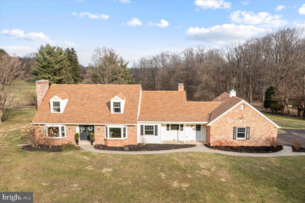This Cape Cod-style home in Solebury Township, elegantly positioned near New Hope and Lambertville, epitomizes the essence of refined country living meshed with modern conveniences. Its serene setting, characterized by expansive views of a captivating pond, establishes an atmosphere of tranquil living from the moment of entry. The home's layout is thoughtfully designed, offering a harmonious balance between spacious living areas and intimate spaces for relaxation and work.

Upon entering, the left wing of the home unfolds into a spacious living room, anchored by a cozy fireplace, an office space conducive to productivity, a full bathroom adorned with a Carrara marble counter double vanity, and a bedroom that promises restful slumber. To the right of the foyer, the layout expands into a commodious dining room, leading to an updated kitchen that seamlessly transitions into a large family room. Here, another wood-burning fireplace stands as a focal point, complemented by a sun-drenched sunroom with vaulted ceilings, new sliders, and windows that frame the idyllic Bucks County landscape and pond views.

The main level is rounded out by a tastefully updated powder room and a practical combination mud-laundry room, providing direct access to the attached two-car garage. This thoughtful design underscores the home's blend of functionality and style.

Ascending to the upper level, the continuity of hardwood floors sets a warm and inviting tone. The primary suite is a haven of luxury, featuring a newly renovated bathroom with his/her sinks and a private shower area, encapsulating modern elegance. The additional bedrooms, sharing a beautifully updated full bath, offer comfort and style, while a versatile bonus room presents opportunities for a fourth bedroom or a communal gathering space.

The home's allure is further amplified by a series of enhancements, including new wood and tile flooring that extends throughout, upgraded windows that invite natural light while offering views of the surroundings, and a spacious eat-in kitchen appointed with granite countertops. The dining room, distinguished by a bay window, opens into the kitchen, fostering an environment ideal for entertaining. The use of porcelain tile, particularly in the great room where it adopts a herringbone pattern that mimics hardwood floors beside an oversized brick hearth, adds a layer of sophistication and warmth.

Situated in the coveted New Hope-Solebury school district, this home is not just a dwelling but a sanctuary that combines the charm of country living with the conveniences of modern amenities, making it a truly desirable residence.