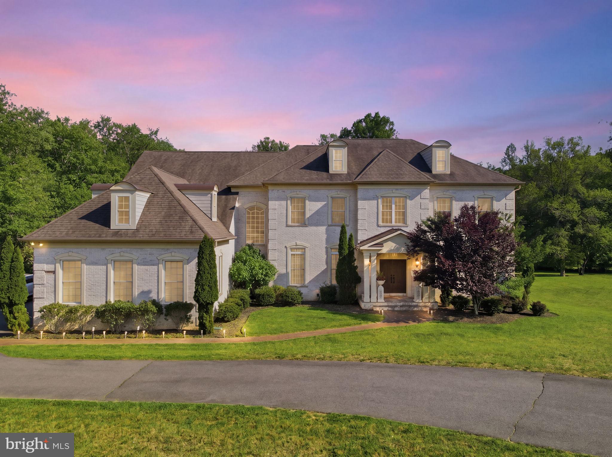 Set on 5 private acres within an enclave of just four homes, this custom-built estate offers over 10,500 square feet of thoughtfully designed living space with 5 bedrooms, 5 full baths, 2 half baths, and a 3-car garage. Graciously set back from the road and framed by mature trees and manicured grounds, the property delivers privacy, scale, and high-level design in equal measure. Inside, dramatic ceiling heights, custom millwork, and abundant natural light define spaces that work equally well for quiet daily living and large-scale entertaining. The gourmet kitchen is anchored by dual marble and walnut islands and equipped with Thermador, Viking, and Sub-Zero appliances, custom cabinetry, and extensive built-in storage — opening naturally to dining and living areas that connect to the outdoor terrace. A paneled library and a private office with terrace views round out the main level. The upper-level primary suite is a genuine retreat — sitting area, fireplace, custom dressing room, and a spa-style bath with walk-in shower and makeup vanity. Secondary bedrooms are generously proportioned with well-appointed bath access throughout. The lower level is built for both recreation and refinement: a private cinema with Stewart screen and 11.2-channel surround sound readiness, a dedicated fitness room, and an oversized wine cellar with brick and wood detailing. Smart-home infrastructure runs throughout — integrated audio, automated lighting and window treatments, video surveillance, and CAT-6 wiring. Outside, an expansive patio and full outdoor kitchen — grill, sink, refrigerator, dishwasher, and volcanic stone bar — anchor a park-like backyard bordered by a gentle creek. A private tennis court completes the picture, with additional open space offering potential for a future pool, cabana, or equestrian use, subject to applicable approvals.
Few properties at any price point offer this combination of acreage, amenity, and seclusion. Offered by private showing only.