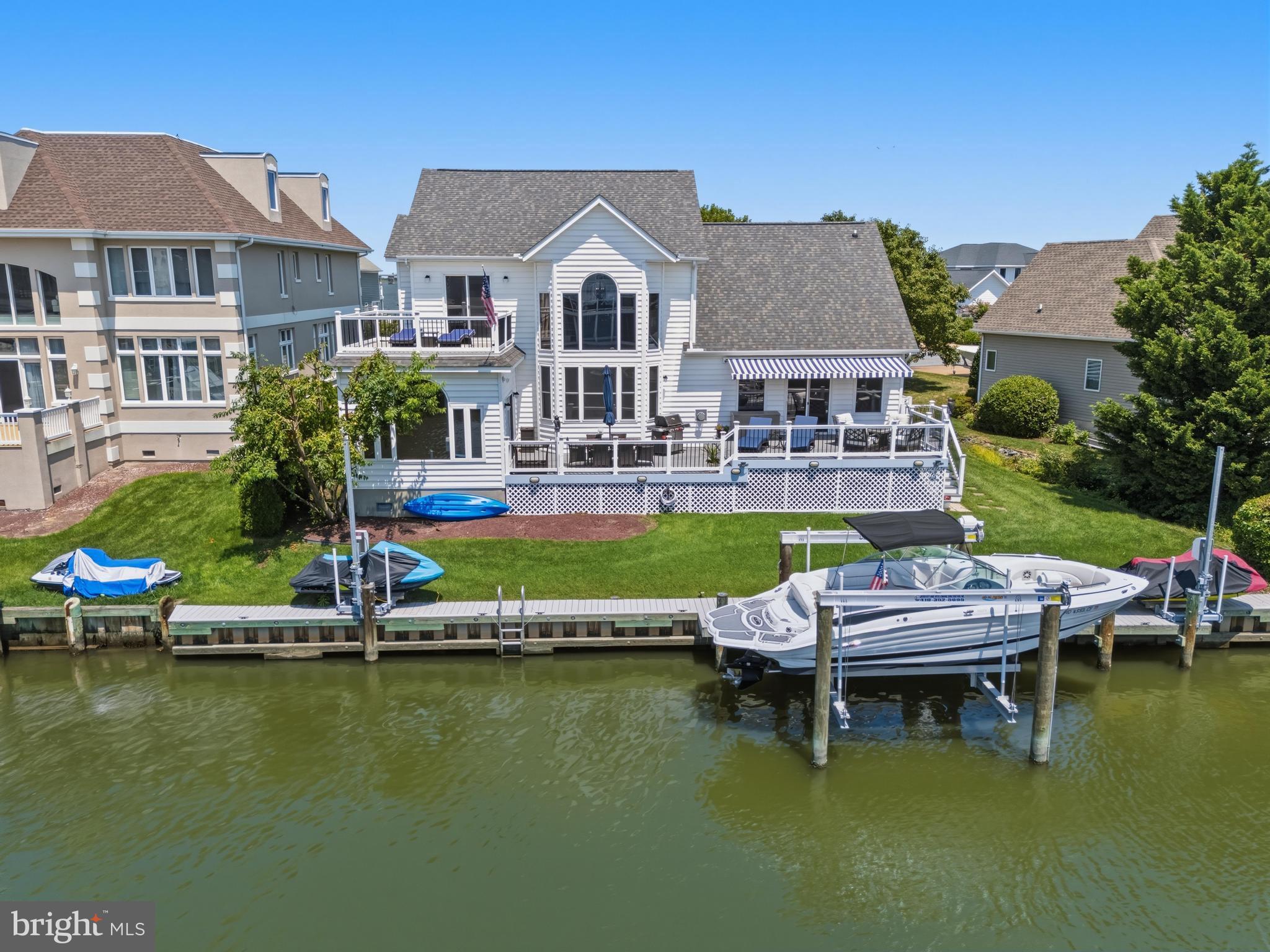 Discover this stunning waterfront home in the desirable community of Ocean Pines Terns Landing, perfectly situated for effortless bay or ocean access. Offering modern upgrades, thoughtful details, and exceptional outdoor living spaces, this property is move-in ready and built for both relaxation and entertaining.
Recent Updates & Impressive Features Include:

New roof (2023).
New deck railings  and  awning  for shaded outdoor enjoyment (2023).
Updated owner’s suite bath (2023) featuring a beautiful granite countertop with new sinks, and toilet.
Custom barn door and a spacious California walk-in closet (2024) in the owner’s suite.
Fully equipped laundry room with cabinets, sink, and granite countertop.
Gourmet kitchen enhanced with remote-controlled over-cabinet lighting (2024).
Tinted windows and newly refurbished thresholds..
Conditioned garage for year-round comfort.
Mature arborvitaes trees providing wonderful privacy.

Waterfront Amenities:

Boat lift installed in 2025 with new electrical post.
Two swivel jet ski lifts (2024) – both included with the sale.

Smart & Efficient Living:

HVAC systems regularly maintained and serviced twice yearly by Coastal Comfort.
Smart thermostat.
Ring security camera system.
Solar light posts.

Additional perks include some TVs that convey with the property. This turnkey waterfront retreat combines luxury finishes, recent investments, and a prime location in Ocean Pines – an ideal setting for boaters, entertainers, and those seeking a peaceful waterfront lifestyle.