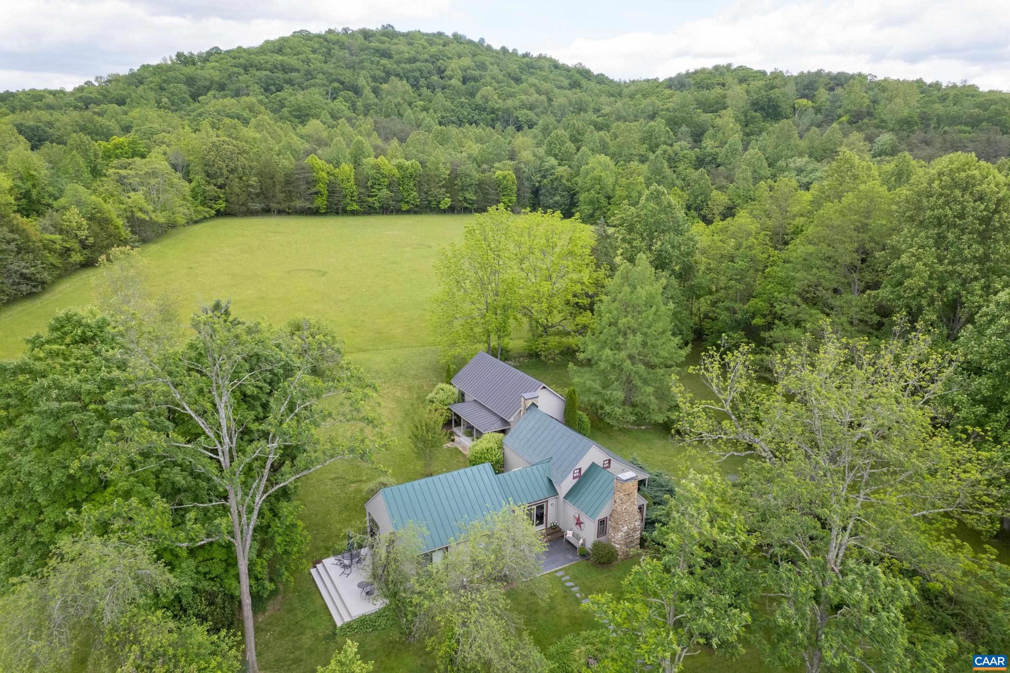 Carefully preserved and updated for comfort, this rare C. 1820 chestnut log cabin is move-in ready for full-time country living or weekend gatherings.  Nestled in the midst of 85 exquisitely private acres in Western Albemarle, the property offers several additional home site options.  The original living room with stone fireplace is the heart of the home. A bright kitchen addition features custom English style cabinets with hand cut stenciling, butcher block counter tops, stainless steel appliances, two generous pantries, an island and slate and pine floors.  Sliding doors open to a wide deck with room for entertaining. A second addition, completed in 2008, leads down a bright, tiled hallway to the primary suite which boasts a vaulted ceiling, cedar closet and red oak window trim and flooring. The entire tract features Blue Ridge views, stocked pond, woodland trails, rolling pastures, streams and vivid night skies.  Harris Mountain Farm is located just 15 mi from Charlottesville and the University of Virginia, 10 mi from the Charlottesville Albemarle airport,  5 mi from a 600 acre county park, and 18 mi from Shenandoah National Park.  The farm is also a short drive from numerous wineries, ski resorts, breweries and orchards.,Cherry Cabinets,Painted Cabinets,Wood Cabinets,Wood Counter,Fireplace in Bedroom,Fireplace in Living Room