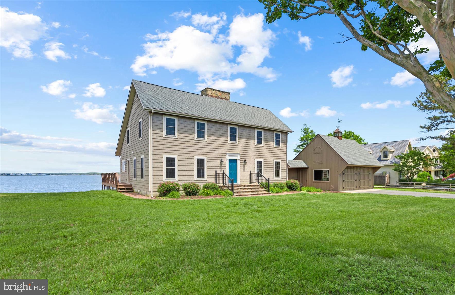 Exceptional bayfront home with 95 feet of direct water frontage, a sandy beach shoreline, and sweeping panoramic water views. Rich in charm and character, this distinctive waterfront residence features reclaimed hardwood floors, three wood-burning fireplaces, and inviting living spaces that capture the beauty of the bay from nearly every angle. Whether enjoying a quiet morning on the water or entertaining family and friends, the wide-open views provide a stunning backdrop year-round. The thoughtfully designed floor plan offers over 2,600 square feet with four bedrooms and 2 full plus one half bath. The main level features a spacious living room, eat-in kitchen, screened porch, patio, and a main-level bedroom with adjacent half bath that has the space to easily convert to a full bathroom. Upstairs, the oversized primary suite includes dual closets, a private bath with soaking tub and separate shower, and stunning water views. Two additional bedrooms and a full bath complete the second level. For boating enthusiasts, deep-water access is nearby, and the property offers the potential to install a private pier, providing direct access to life on the bay. Additional features include a detached garage, abundant storage, and an exceptional waterfront setting that is rarely available. Situated on a quiet, non-thru street, steps to the Cripple Creel Golf and Country Club, this is the perfect location—just a few miles from the beach, yet tucked away from the crowds and surrounded by the tranquility of waterfront living.