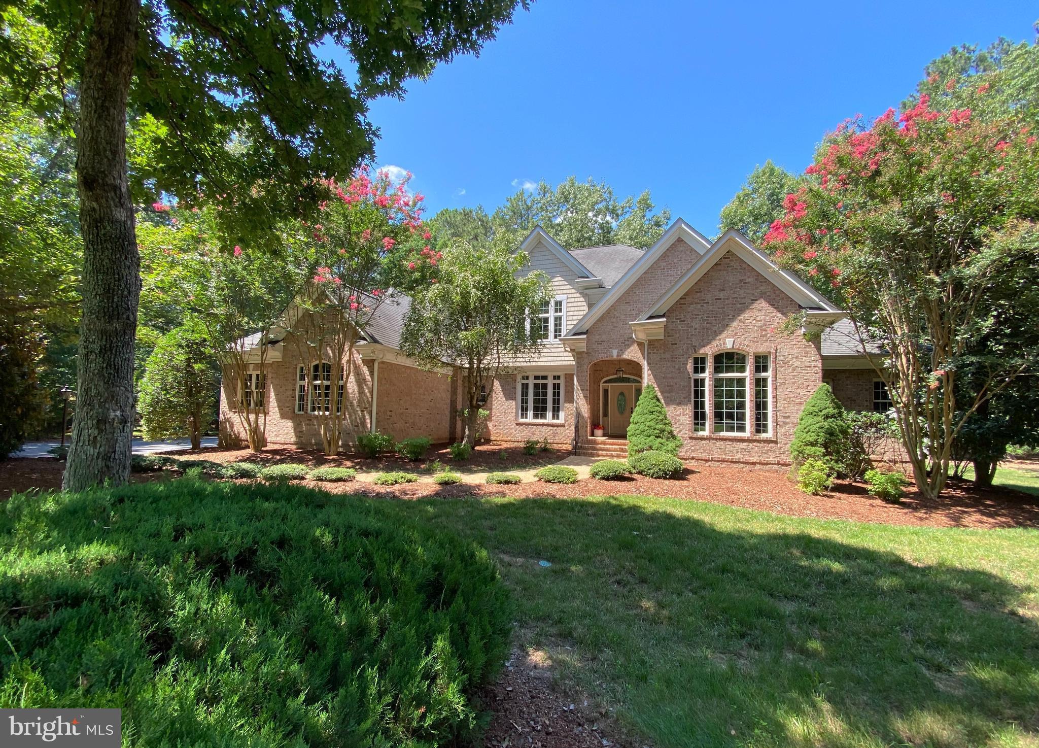 Beautifully anchored within the prestigious gated, amenity-rich community of Fawn Lake, this exceptional custom brick Dream Home offers timeless elegance, impeccable craftsmanship, and over 5,600 square ft of beautifully finished living space designed for luxurious everyday living.
Perfectly positioned on a private 0.78-acre homesite backing to mature trees, this stunning residence showcases exquisite architectural details, sophisticated finishes, refinished solid hardwood Oak flooring, and thoughtfully designed living spaces.
An impressive grand foyer welcomes you with a breathtaking curved staircase adorned with custom wainscoting, creating an unforgettable first impression. The spectacular two-story Great Room, features a dramatic wall of windows, a stunning coffered ceiling, a designer chandelier,  and a gas fireplace anchored by built-in cabinetry. 
A beautifully appointed Formal Dining Room provides an elegant setting for celebrating special moments. The gorgeous private study, highlighted by tall coffered ceilings, Palladium windows and French doors, creates an ideal executive home office.
The well appointed Gourmet Kitchen is equipped with custom cabinetry, Sub-Zero Fridge, six-burner Wolf gas Range, and granite countertops. The adjoining sunny breakfast area flows seamlessly into the  a cozy Family Room with a striking stone fireplace.
The gracious main-level Owner's Suite offers a private sanctuary featuring a sitting room, a luxurious spa-inspired bath complete with dual vanities, custom cabinetry, a relaxing soaking tub, and an oversized tiled walk-in shower.  A fabulous, huge  walk-in closet with custom built-ins, drawers, and a dedicated shoe closet offers ample wardrobe organization. 
The laundry room features a utility sink and cabinetry for extra storage.  A convenient rear staircase enhances everyday functionality.
The upper level offers spacious accommodations, with three Bedrooms, each featuring its own private ensuite bath and walk-in closet, ensuring exceptional comfort and privacy for family and guests.

The fully finished lower lower level expands the home's exceptional living spaces with a huge Rec Room,  Wet Bar,  fitness room, elegant marble-floored office with French doors,  a private guest suite with full bath, and  a fitness room, creating the perfect setting for entertaining, recreation, or extended guest accommodations. 
Outdoor living is equally inviting with a stone walkway, courtyard,  maintenance-free deck overlooking the beautifully landscaped backyard enhanced by mature hardscaping, an in-ground irrigation system, and tranquil wooded views that provide exceptional privacy.

Every detail has been thoughtfully curated to provide comfort, convenience, and peace of mind, including a whole-house generator, water softening system, and  central vacuum!
The oversized three-car garage equipped with an EV charging station and storage cabinetry, features beautiful Carriage doors that add charm to the exterior.  
This extraordinary residence offers an exceptional opportunity to experience luxury living at its finest.  
Ideally located just steps from Fawn Lake's award-winning resort-style amenities, including the private lake, sandy beach, marina, championship golf course, driving range, clubhouse with waterfront dining, swimming pool, tennis and pickleball courts, walking trails, parks, and more.  
The beautiful luxury and vibrant Fawn Lake Community offers amazing amenities such as a boating recreational lake, sandy beach, an Arnold Palmer designed Golf Course, Community ClubHouse and marina.  An array of clubs, groups and daily activities, offer plenty of opportunities to join the social scene, make new friends and remain active! Located in the countryside near the town of Fredericksburg, surrounded by park lands. Minutes to shopping, restaurants, top-rated Riverbend District schools and I-95!