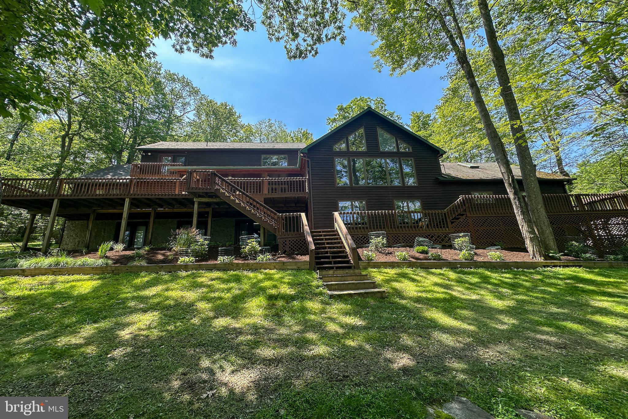 Exquisite Lakefront Log Home Retreat at Deep Creek Lake. 
Nestled on a private, wooded 1-acre lot with 169 feet of pristine lakefront along a serene cove on the southern end of Deep Creek Lake, this well-maintained log home offers the perfect balance of rustic charm and luxurious lakefront living. 
From the moment you arrive, the home’s park-like setting and lush landscaping welcome you into a world of tranquility. Step onto the expansive lakeside deck—partially covered for year-round enjoyment—and take in sweeping views of the water, the perfect backdrop for entertaining or peaceful morning coffee.
Inside, this spacious 4,284 sq. ft. retreat spans three levels and features 4 bedrooms and 3.5 fully updated baths. The main level primary suite boasts lake views, a walk-in closet, private bath, and direct access to the deck, offering comfort and privacy. Two of the upper-level bedrooms share a beautifully updated bath, both enjoying stunning lake views. 
The heart of the home includes a grand lakeside great room with panoramic views, and an adjacent billiards room, both with forced-air heat and central A/C—plus a warm and inviting living room with an elegantly finished stone fireplace illuminated by spotlights. The open-concept kitchen features updated appliances, tile countertops, and a counter-height peninsula flowing seamlessly into the dining area, which also walks out to the lakeside deck. 
The finished walk-out lower level is designed for relaxation and recreation with a family room featuring a wood stove set in a custom stone wall, plus a spacious rec room—all with access to a lakeside patio. A shared three-quarter bath on this level ensures comfort for guests. 
Boating enthusiasts will appreciate the Type A dock permit, allowing two power boats—ideal for enjoying Deep Creek Lake to the fullest. A two-car attached garage and additional one-car integral garage provide ample storage, with extra driveway space for guests. 
Whether it’s the intimate indoor details or the unmatched outdoor setting, this one-of-a-kind lakefront home delivers the ultimate Deep Creek Lake experience. Don’t miss this rare opportunity to own a luxurious escape in one of the region’s most peaceful coves. 
Schedule your private showing today and experience lake living at its finest.