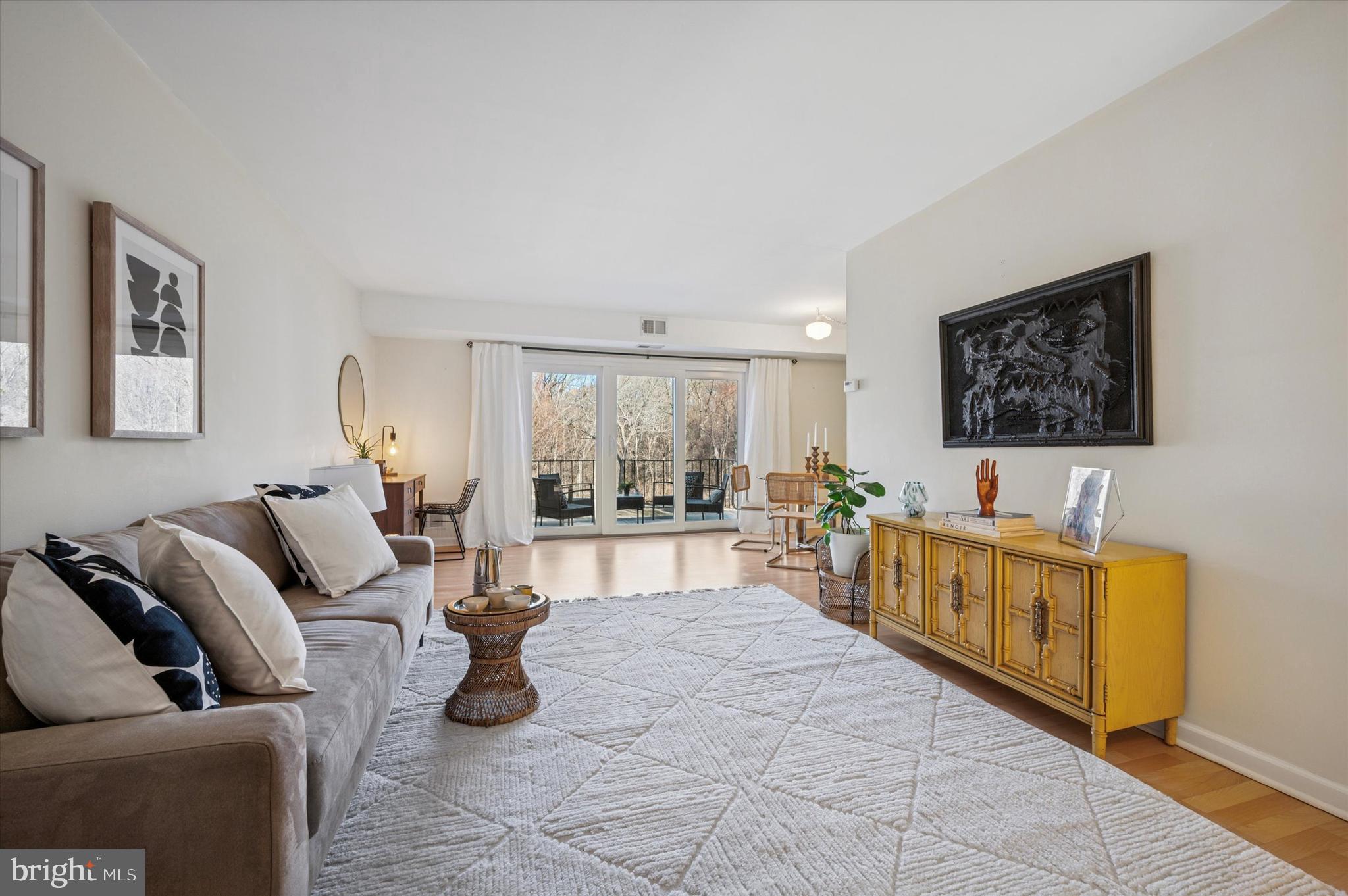 This lovely, light-filled condominium is in the highly sought-after Cresheimbrook community, which borders Fairmount Park and has an idyllic park-like setting. The single-level floorplan with blond laminate flooring throughout offers an L-shaped main living area that’s large enough for both a spacious living room and dedicated dining area, with plenty of breathing room in between. It is flooded with light from sliding glass doors to the balcony with a serene view of the condo grounds and lush woods beyond. The galley-style kitchen has crisp white cabinetry and appliances, including a Bosch dishwasher and Euro-style laundry machine, and granite countertops with undermount stainless steel sink. The ceramic tile hall bath has a storage vanity and original cast iron tub and is just outside the sunny bedroom, which easily fits a king-size bed and has a full wall of closets. There’s no shortage of storage here–there’s a large coat closet at the unit entrance, a linen closet outside the bathroom, storage space in the mechanical closet off the balcony, plus a storage unit in the shared basement. While the setting itself feels far from urban–there’s even a trailhead right across the street from the community parking lot–it’s an easy walk to the Allens Lane SEPTA station and super convenient to West Mt Airy shopping and dining.