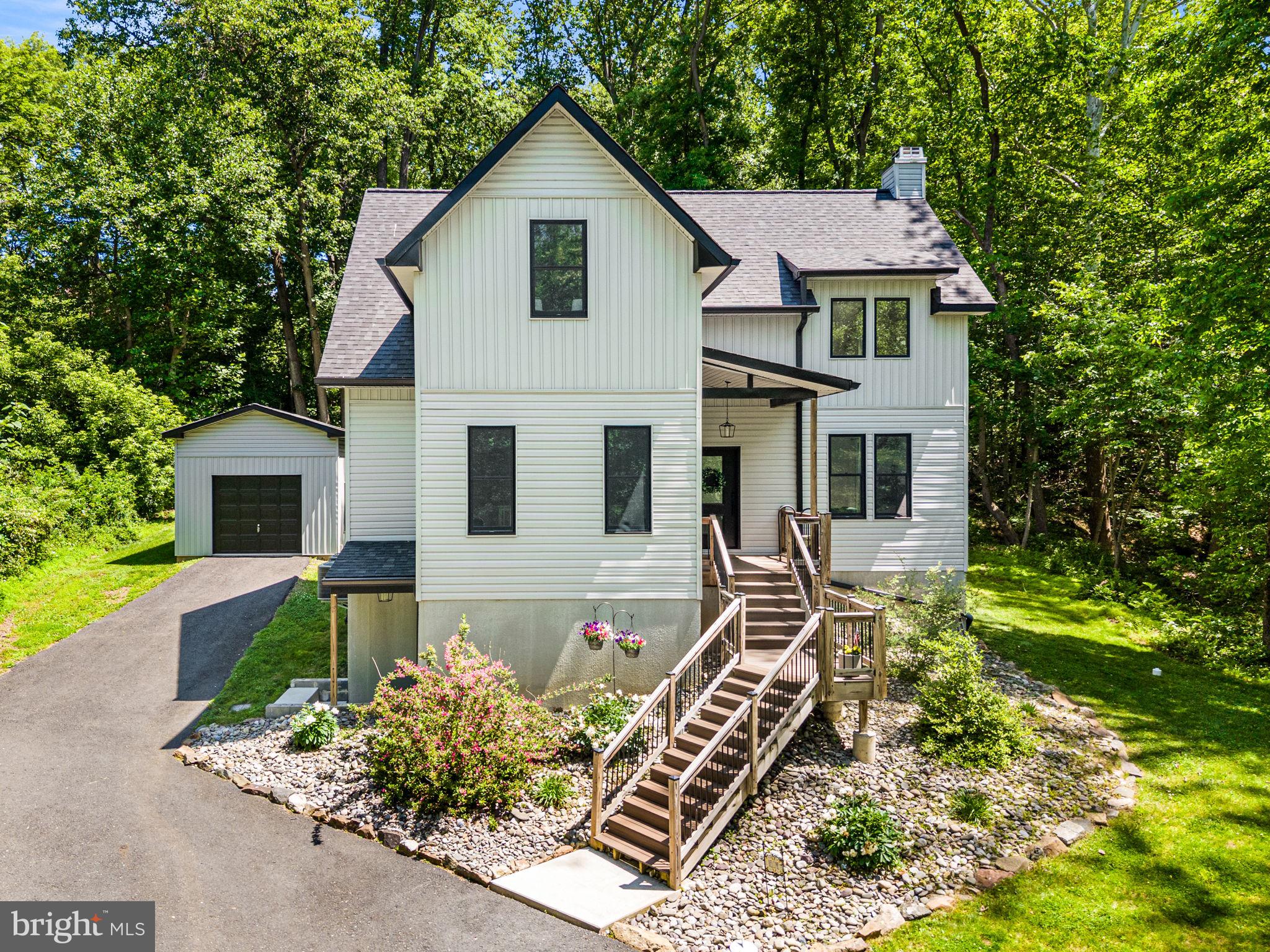 Tucked away on a picturesque, wooded setting, this custom-built contemporary home offers the perfect blend of modern design, privacy, and everyday comfort. Surrounded by nature yet conveniently located close to everything Lower Bucks County has to offer, this stunning 3-bedroom, 2.5-bath residence boasts nearly 2,000 square feet of thoughtfully designed living space. Step inside to soaring ceilings and an impressive two-story great room filled with natural light from oversized windows that bring the outdoors in. The open-concept floor plan seamlessly connects the living room, dining area, and beautifully appointed kitchen, creating the ideal space for entertaining and everyday living. The chef-inspired kitchen features custom cabinetry, quartz countertops, a large center island, stainless steel appliances, and designer finishes throughout. The spacious primary suite on the first floor offers peaceful woodland views, generous closet space, and a beautifully finished en-suite bath. Two additional bedrooms on the second floor provide flexibility for family, guests, or a home office. A versatile loft overlooking the great room adds even more functional living space for play, homework area, etc. Outside, enjoy your own private retreat from the expansive covered rear porch overlooking the serene backyard and surrounding trees. Whether you're sipping your morning coffee, hosting gatherings, or simply enjoying the sights and sounds of nature, this outdoor living space is sure to impress. For even more finished square footage, the full basement has its own exterior entrance with a walk out, 9' foot ceilings, and already framed out with insulation and lighting - just waiting for the new owner to complete it- there is enough room to add a 4th bedroom, additional bathroom, office, recreation area, home gym and more. The detached garage, extensive hardscaping, and beautifully maintained grounds complete the property.  With 3 total parcels making up this property, you have over 1 acre of land to enjoy- with LOW taxes of only $5300/year.  The cherry on top is the public water and public sewer utilities. A rare opportunity to enjoy modern construction, breathtaking natural surroundings, and a lifestyle that feels miles away from it all—while remaining just minutes from shopping, dining, major commuting routes, and everything Bucks County has to offer. This is more than a home; it's a destination. Schedule your private tour today.