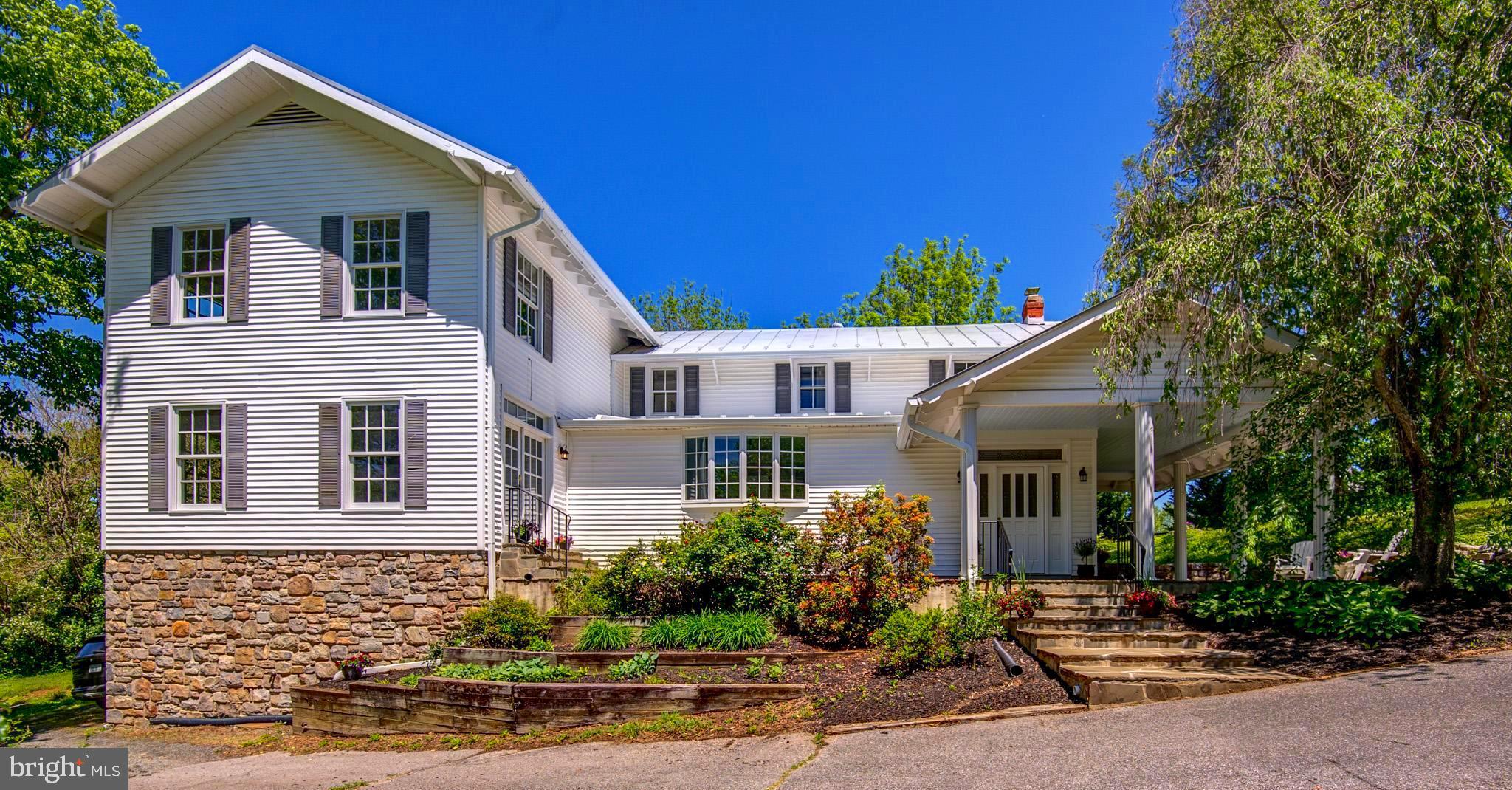 Nestled in the heart of the historic village of Paeonian Springs, this stunning white farmhouse offers an extraordinary blend of historic character and countryside charm. Sited on 5 bucolic acres—including a separately deeded 2-acre lot—find a rare retreat surrounded by ancient trees, rolling pastures, and the timeless beauty of one of Loudoun County’s most cherished hamlets. From the moment you arrive, the home exudes warmth and welcome. While the front of the home showcases gracious entertaining spaces, the natural farmhouse-style entrance is found at the side—where a wide flagstone patio leads to a deep, impressively scaled porch supported by six graceful columns. The porch offers both sun and shade, while lush landscaping—hostas, lilies, roses, and shade trees—creates a serene, colorful setting for relaxed dinners, summer barbecues, or joyful birthday parties. Enter at the side foyer where whimsical beadboard sets a welcoming tone—and the home opens to two inviting everyday living areas: a large family room anchored by a stone wood-burning fireplace and a newly renovated (2025) kitchen featuring high-end KraftMaid cabinetry, stylish quartz countertops, and traditional white subway tile. A sunny bow window frames views of the garden and pastureland. Additional matching hall cabinetry serves as a perfect prep and storage area. Across the main floor, rich hardwoods create continuity and warmth. In the newer section, the dining room brilliantly captures the spirit of another era—where Sunday dinners and elegant parties brought people together. With its generous scale, the room accommodates large gatherings with ease -a grand Palladian window fills the space with natural light- perfect at dusk. The nearby living room offers a second main-level gathering space—ideal for holiday celebrations and quiet evenings alike—with natural flow from the dining room and kitchen. This comfortable room features custom built-ins, a gas fireplace with a mantle to hold your favorite art and a set of elegant French doors that step down to the front flagstone patio—further enhancing the fantastic flow of the main floor .  A centrally located laundry room and a discreet powder room add comfort and convenience to the main level. Upstairs, what begins as a landing, opens into a spacious and open, light-filled room—the perfect-home office, homework station or upper media area. New carpet (2025) adds comfort underfoot and Comcast Xfinity high-speed internet supports streaming. The Primary Suite includes lush carpet, ceiling fan, walk-in closet, and a beautifully appointed (2025) bath with double vanity and a dual showerhead deep shower with built-in bench seating. Two additional upper bedrooms are located in the home’s historic wing, where original pine floors and charming angled ceilings add warmth and timeless character.  A thoughtfully updated hall bath (2025) has a deep tub/shower, stylish tilework, and a linen cabinet. Outside, the gently rolling property includes a fenced pasture and a two-stall barn with run-in and feed/storage room.  Above the barn a fully floored room with its own private entrance from the lawn—provides an incredible space- ideal for a yoga studio, home office, or an exceptional tack room. Once home to Paeonian Springs’ beloved horse CJ—who lived to the age of 36—the barn and land are rich with legacy and potential. A two-car garage is integrated beneath the front of the home, offering convenient parking and an additional flex space is located on the same level as garage. There is not an HOA here. Bring the chickens, bring the horses, and your imagination. Whether you're dreaming of a country escape, a working farmette, or a historic homestead with modern comforts, this timeless property is 25 minutes to IAD and 5 minutest to the Dulles Greenway. Rare opportunity to own a piece of Loudoun County’s most enchanting countryside.  New Roof 2019, other newer systems. Whole House generator.