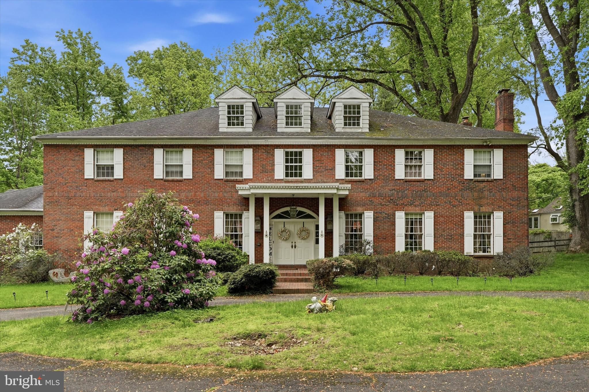 Built like a classic 19th-century estate but fully updated for modern life, this custom brick Colonial sits on 2.35 private acres in Huntingdon Valley. The main floor features 10-foot ceilings, detailed trim work, and a grand two-story foyer with a sweeping staircase. At the heart of the home is a newly renovated chef’s kitchen that opens to a rear patio, a heated in-ground pool, and a built-in spa.The layout offers ultimate flexibility: a main-floor bedroom suite and dedicated office sit privately off the kitchen, while the second floor hosts four massive bedrooms—including a primary retreat with a sitting area, dressing room, and a steam shower. Downstairs, the 3,000 sq. ft. finished basement features a guest room/gym/office space and another full bath. Located in the award-winning Lower Moreland School District, this property offers a rare combination of total privacy and neighborhood convenience.