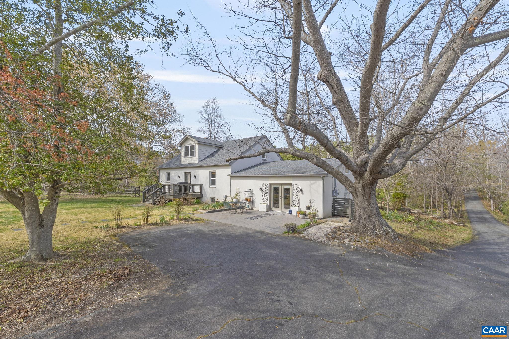 Don't miss this opportunity. Meticulously improved and maintained, mini-farm, with boundless options, and multigenerational living.  Ample room for horse paddocks, goats, chickens and pets.  Current fencing only for chickens, dogs and pool (not horses). 5 + acres features gorgeous main house, inviting swimming pool, perfectly adorable cottage, edible fruits + vegetables, plus an amazing workshop. Between the solar net metering and cottage rental, this property works for you. The main house showcases beautifully refinished hardwood floors, soapstone counters, Kitchen Aid appliances, loads of built in bookshelves, tile in all bathrooms, exposed beams and loads of sunlight. The cottage provides main level living, can be enjoyed fully independent of the main house, w/ private back deck.  Both dwellings have been significantly remodeled + updated with personal touches. The vanity in the primary bathroom is made from felled on-site tree. Cozy up w/a book on the day bed! Solar system (paid off) installed in 2020, updated 2026. Well + septic recently serviced. New roof in 2018. 2 car garage and workshop is a huge value not to be missed - could serve as kennel. New HVAC in cottage 2025. Ask for extensive list of edible fruits + veggies!,Soapstone Counter