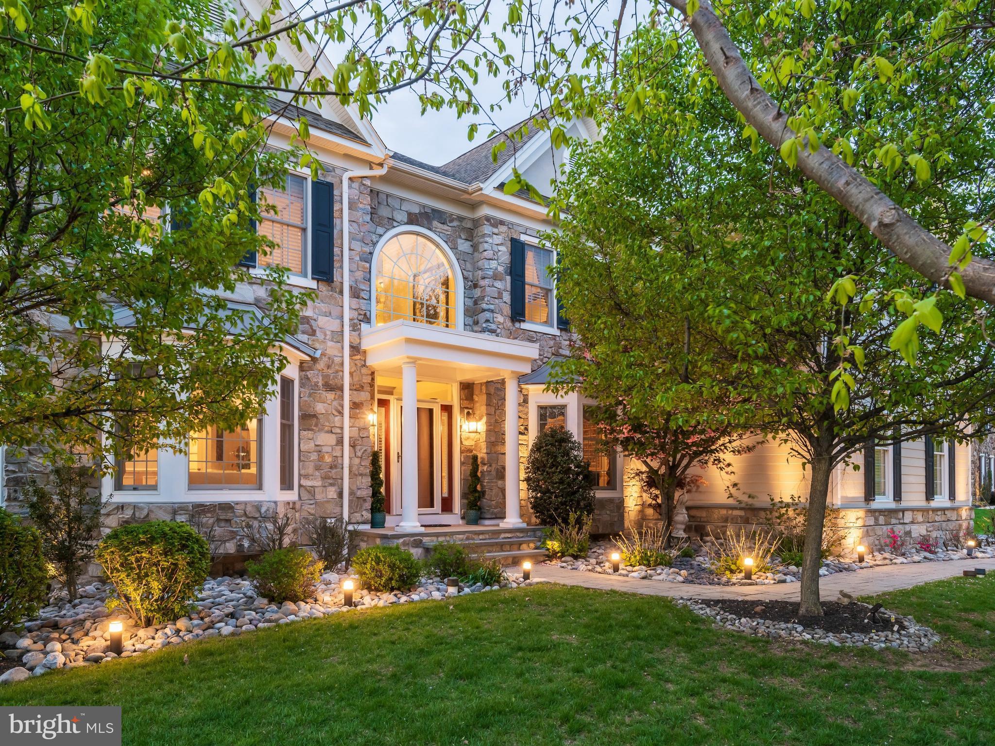 A DISTINGUISHED PRESENCE! Open House Sunday, 5/31, 1-3 p.m. Situated on a desirable, premium home site, this stately stone-front manor offers a seamless blend of timeless elegance; airy design plan; modern functionality, and exceptional lifestyle convenience. Enjoy picturesque, front-to-back green views and easy walkability to the community pavilion, park and ponds, fitness center, recreation barn, trail, pool, and sport courts in the legendary enclave, Liseter.  A grand, sunlit two-story foyer with a sweeping staircase creates a commanding first impression, flanked by refined formal living and dining rooms adorned with opulent trim/molding, ceiling treatments, and walk-in bay windows that capture brilliant natural light. Softly gleaming wood flooring, found in much of the home, reflects the luminous life spaces of this well-windowed interior. Designed for both everyday living and entertainment, the open-floor plan unfolds into a stunning two-story great room/fireplace filled with an ethereal, light-drenched ambiance. At the heart of the home, the adjacent chef’s kitchen features stainless steel appliances, rich granite countertops, large center island with seating, custom tile backsplash, under-cabinet lighting, built-in desk station, and TWO step-in pantries. The sizable breakfast area and adjoining vaulted sunroom create a seamless indoor-outdoor flow to the expansive composite deck and screened gazebo—imagine effortless hosting or lazy day relaxation in this easy, intuitive layout. The main level is completed by a private study with custom built-in work centers, exquisite powder room, secondary stairs, well-planned mudroom with roomy closet, and spacious laundry with tub, cabinetry, and outside entrance.
Upstairs, a wide hall, highlighted by the refined aesthetic of espresso toned wood flooring and sophisticated iron staircase, leads to four generously sized bedrooms. The luxurious primary suite boasts wood floors, ample sitting room, three custom-shelved walk-in closets, dressing/vanity area, and spa-inspired primary bath with serene soaking tub, double vanity, glass-enclosed shower, custom tile, and private water closet. One secondary bedroom features a well-endowed walk-in closet and en-suite bathroom, while bedrooms two and three access a well-appointed third full bath. A ready-to-finish, walk-out lower level with glass door, two full-size windows, and bath plumbing rough-ins, is primed for your creative expansion of living area with your perfect personal design desires. There is also plentiful storage and mechanical utility access including manabloc direct run plumbing center. The immaculate three car garage awaits your pampered autos with epoxied floors and storage loft.
This is a rare opportunity to own a thoughtfully designed home in one of the Main Lines’s most desirable communities—offering not just a residence, but the sought-after “Liseter” lifestyle with residents enjoying exceptional resort-like living amid beautifully maintained grounds with two ponds and hundreds of acres of preserved open space. Amenities include an entrancing infinity-edge pool, superbly appointed clubhouse with fitness center/yoga studio, tennis and pickleball courts, basketball court, scenic walking/running/biking trails, and inviting gathering places like the splendid timber-framed party barn and pleasant open-air pavilion. Liseter’s vibrant, community-oriented atmosphere provides a full calendar of events including outdoor concerts, Oktoberfest celebrations, First Friday cocktail parties, food trucks, and seasonal festivities—creating a true neighborhood experience. Moments away, Ellis Preserve features Whole Foods and a variety of restaurants and shops. With nearby Episcopal Academy, popular Marple Newtown school district, and easy access to Center City, Philadelphia International Airport, the train and transportation routes, 3805 Woodland Drive may be your ultimate lifestyle sanctuary.