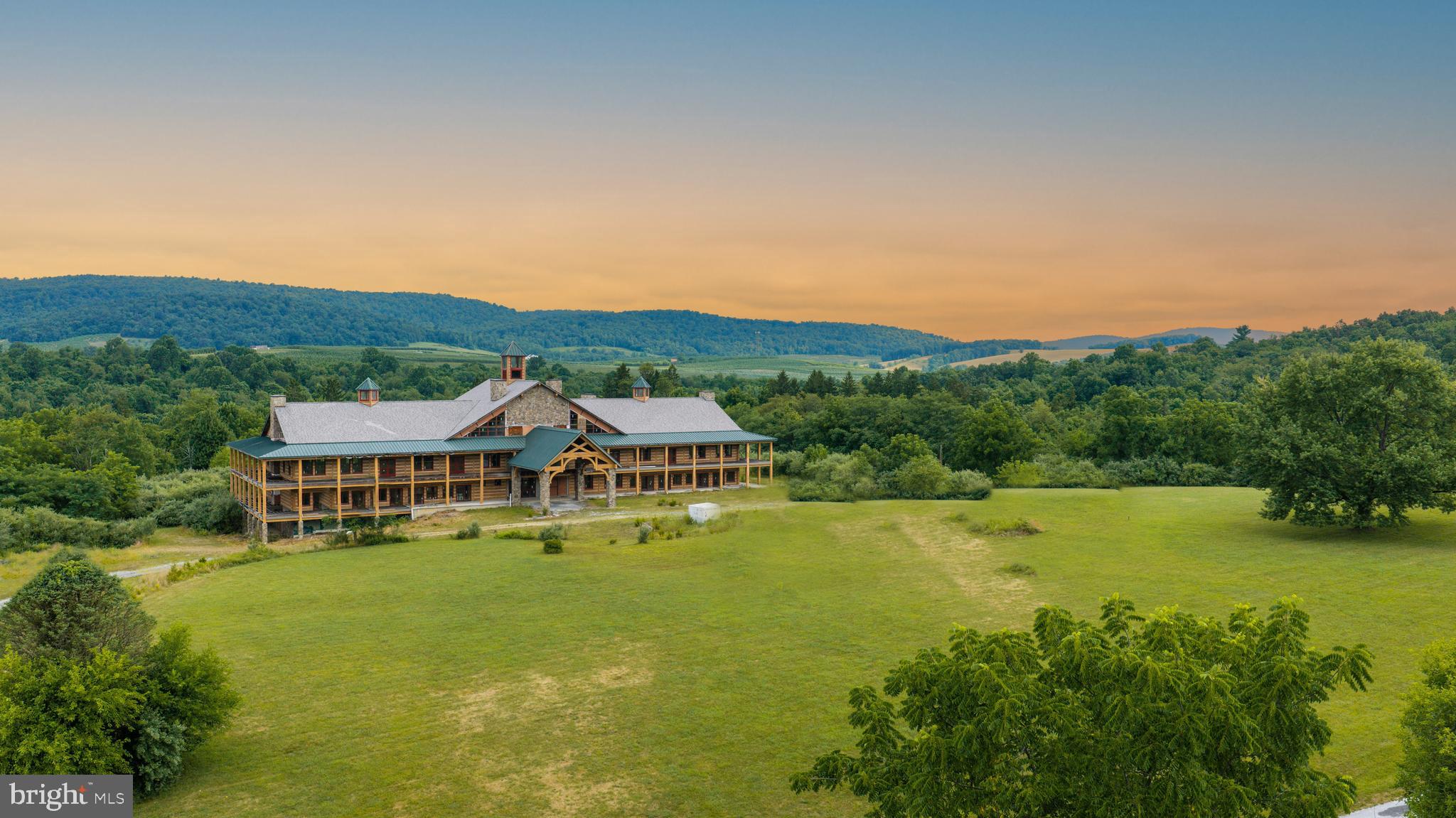 Generals Mountain Lodge is a 634± acre entitled resort and lodge development eight miles from downtown Gettysburg, in Franklin Township, Adams County. This is a one of a kind property. It offers what cannot be recreated in this market: a large, contiguous, permanently protected landholding wrapped around a hospitality core that is already substantially built.

Start with the lodge, because the hard part is behind you. Contractors and engineers familiar with the project put it at roughly 70% complete and available to assist in finishing the project. The infrastructure required by the approved Final Land Development Plan has been built, with the exception of final grading, the parking lot, and other minor items. What remains is finishing work and the next owner's vision.

The lodge appears to be heavy timber. It is not. The structure is weather resistant concrete, formed and finished to read as timber. No cost was spared. Years and $10M+ have gone into the lodge and the work completed to date. Plans call for 18 keys, two ballrooms, a commercial kitchen, and elevators. Complete it as a wedding and event venue, a hunting lodge, a resort, or a hotel.

The property sits in Franklin Township's Agricultural & Open Space district. A zoning text amendment, a Special Exception for Resort/Lodge use, a separate Special Exception for a bed & breakfast in the stone house, and the Final Land Development Plan with four waivers are all approved. All of it transfers to a new owner.

The property produces income from day one, without the lodge. Three residences totaling 7,703 sq. ft. convey separately.

The picturesque 5,838 sq. ft. main house is configured as a hospitality property and carries the bed & breakfast exception: five guest suites, each with a private bath, three with sitting rooms. A great room and a formal dining room each open to their own sunroom, served by a large kitchen. Nine fireplaces. An attached two-car garage and terraced patios complete the build.

A charming 864 sq. ft. cottage nearby offers one bedroom, one bath, and a newly renovated kitchen. Near the main entrance, a 1,000 sq. ft. ranch-studio offers two bedrooms, one bath, and an attached two-car garage. Eight bedrooms and seven baths across three independent homes: immediate rental income, owner's quarters, and staff housing.

Outbuildings add 6,750 sq. ft: A 4,000 sq. ft. Quonset hut attached to a silo, a 2,500 sq. ft. bank barn with animal pens and a second silo, and a 250 sq. ft. woodshop with electricity. The property is served by natural gas. That's right, natural gas! A HUGE benefit!

This property offers more than one future. Complete the residences as a private compound and legacy landholding, leaving the lodge as is and the property at its current land-based assessment, while retaining an entitlement that conveys if you change your mind. The unencumbered acreage also carries multiple lot subdivision potential.

And then there is the land itself. 634± acres of remarkable seclusion: rolling woodlands, riparian forest, meadow, and ridgeline. 500± acres are enrolled in a conservation easement and permanently protected. The remaining 134± acres are unencumbered and carry the hospitality exception. The views are incredible, long and open across ground no one will ever build into. Adams County's well known orchards neighbor the property. A state-stocked trout stream runs through, an approved trout water designated by the Pennsylvania Fish and Boat. The woods hold whitetail deer and wild turkey. The easement permits passive recreational use, including hiking, fishing, nature study, and trail development.

Come walk it. Stand on the ridge, look out over the orchards, and decide which future you want to build.

Buyer to verify all entitlements, permits, subdivision potential, and construction status. NPDES earth disturbance permit renewal required to continue build; see broker for status. Documentation package available to qualified buyers upon request.
