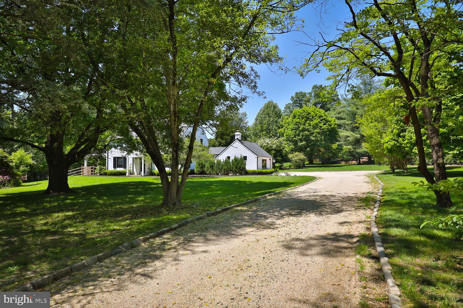 Welcome to this beautifully designed and updated 4-bedroom, 4-full bath country estate home that blends historic charm with modern luxury; set back on 2.68 acres of professionally designed and landscaped grounds in Flourtown, Springfield Township.
This home offers the perfect blend of tranquility, privacy and community.  It is located within the Top-Rated Springfield Township Public School District with the convenience of easy access to Chestnut Hill, Center City Philadelphia, Philadelphia Airport, and major Pennsylvania highways.  
The center of the home is the Great Room, where a beamed cottage-style ceiling and a hand-built stone fireplace, flanked by custom cabinetry, create a spacious and cozy gathering space for family and friends. The professional chef designed kitchen is a cook’s dream, featuring an expansive custom center island with white granite countertops, gas cooktop with a retractable vent, double ovens, farmhouse sink, large pantry, and coffee bar that includes wine storage with a large built-in fridge. The home features teak hardwood floors throughout and custom window treatments. 
Adjacent to the great room, through customs glass sliding doors, is a large bluestone patio that offers a serene space with uninterrupted views of the gardens of flowers and heritage trees.
The formal dining room overlooks the front gardens and leads to a second spacious living room with a second fireplace and large picture window overlooking the grounds.  This room has access to a covered porch with ceiling fans, ideal for three-season enjoyment. A large, fenced dog run adds convenience for pet owners.
Completing the first floor is an office/au pair suite/guest room with garden views, a full marble bath with heated floor, which can be easily added to the living room to create a larger private in-law suite with private entrance.
Every window and patio door in this light-filled home has been thoughtfully placed to offer expansive views of the spectacular grounds. A custom staircase, illuminated by a skylight and chandelier leads to the second floor.
The main bedroom, featuring a cottage-style ceiling, opens to a private deck and features a personal spa with heated floors, a 6-foot soaking tub and glass rainfall shower. Two additional bright and spacious bedrooms share a beautifully appointed marble bath, also with a heated floor.
The home includes a large, finished lower-level flex room with full bath, heated floors and built-in cabinets, perfect for a movie room, playroom, home gym or guest suite. In addition, there is a separate finished large laundry and storage room.  Finally, the attic space above the 2nd and 3rd bedroom is finished, insulated and well prepared for long term storage. Smart home security system.