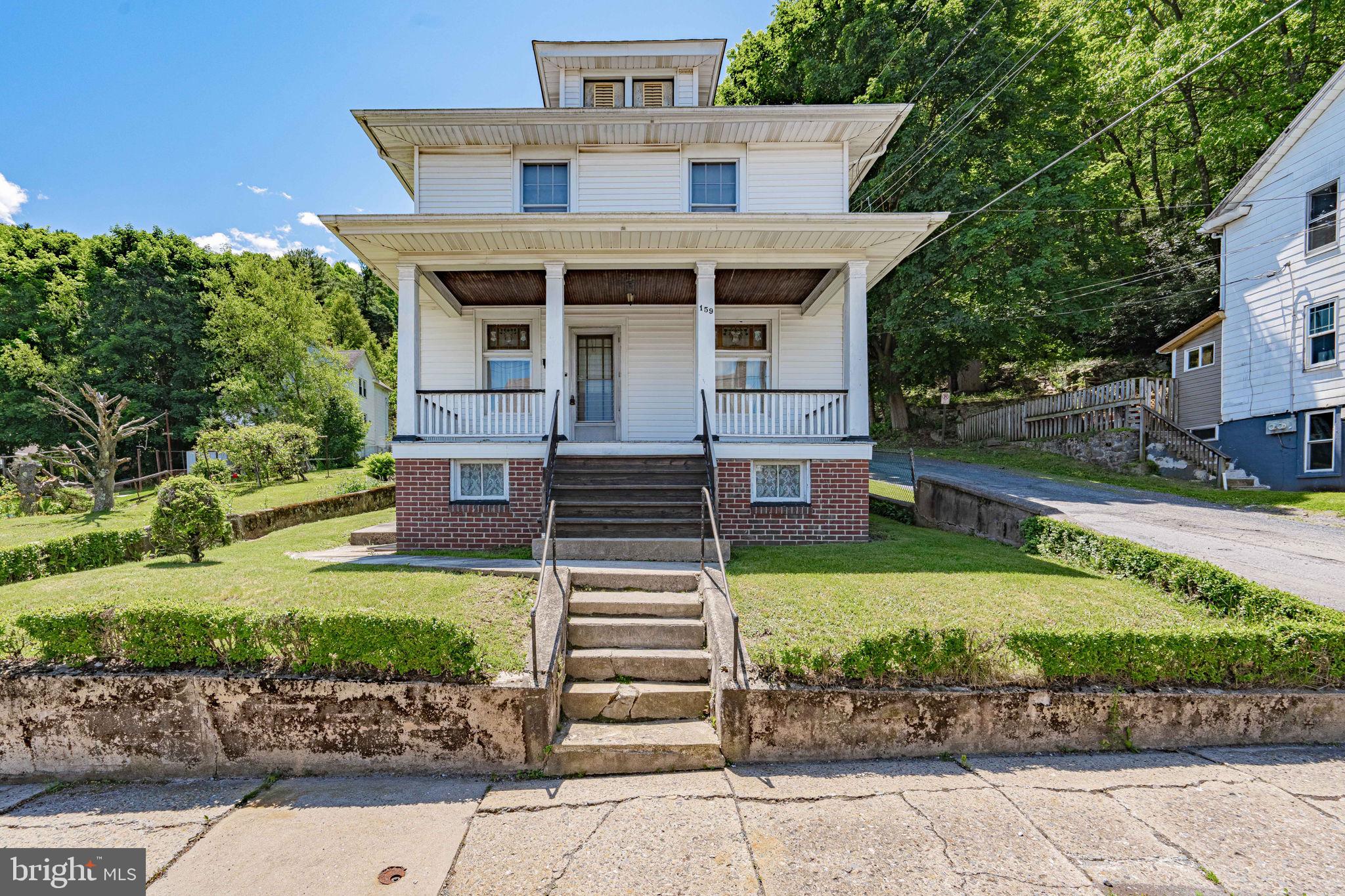 ** Back on the market through no fault of its own.  Buyer got cold feet, due to family pressure. ** Discover serene hillside living at this charming Nesquehoning Borough residence, where a classic facade with brick and vinyl siding offers immediate curb appeal and room to breathe with an additional park-like lot. A welcoming covered porch invites residents to relax and enjoy the verdant, tree-lined surroundings and captivating mountain views. This property provides a perfect blend of traditional charm and functional living spaces. Step inside to find a grand wooden staircase with intricate banisters defining the entry, leading to versatile interiors. The adaptable living areas are characterized by ornate wood built-ins, archways, and abundant natural light, creating an inviting atmosphere. Plush carpeting and warm wood trim are found throughout, ready for personal touches. An inviting dining area, featuring a classic chandelier and warm, neutral tones, is ideal for formal meals. The functional eat-in kitchen boasts ample wooden cabinetry, a range, a refrigerator, and vinyl flooring. Bedrooms are well-lit and comfortable, offering soft carpeting(and hardwood under the throw rug and classic wood trim. Bathrooms provide essential amenities, including a functional vanity, standard tub, and convenient walk-in stall. The utilitarian basement features concrete flooring, a laundry sink, an electrical panel with fuses, and provides ample storage and workshop potential. The spacious, verdant lot is enhanced by green landscaping, mature trees, and a fenced backyard, offering privacy and a peaceful setting. This charming home is nestled against a backdrop of natural greenery, providing an exceptional living experience with tranquil mountain views.