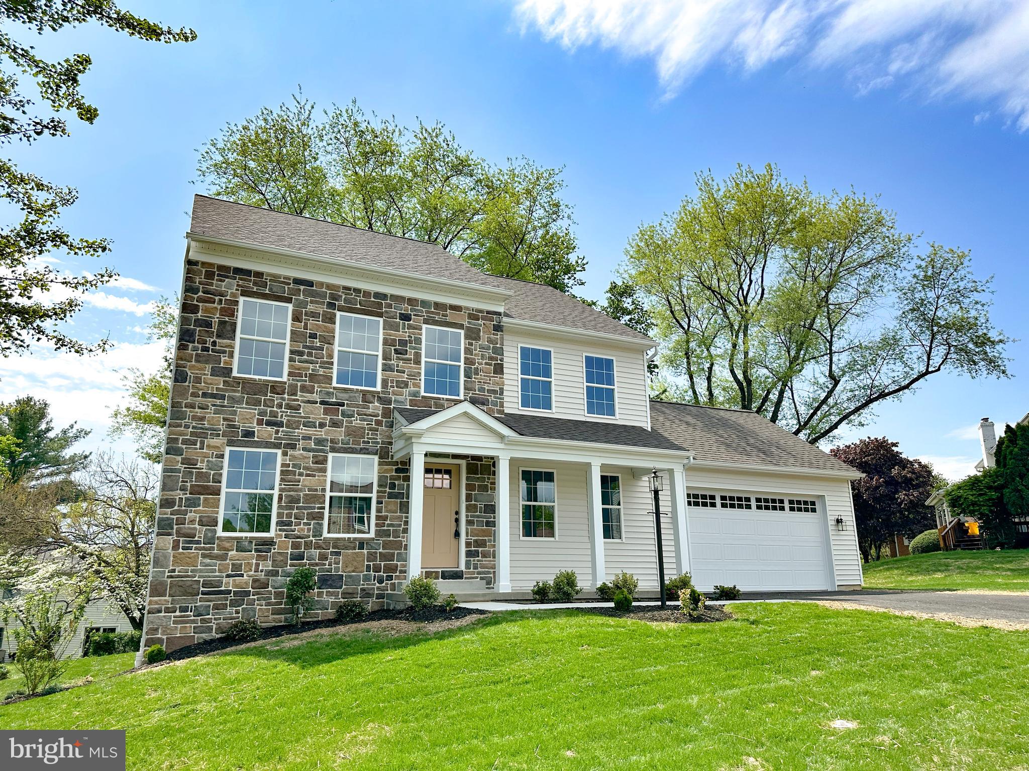 The builder has decided to finish 426 sq ft of the basement to add additional living space!  Brand New Home in an Established, Tree-Lined Neighborhood. Don’t miss this rare opportunity to own a brand new home in one of the area's beautiful, mature, and walkable neighborhoods! Nestled among tall trees and surrounded by well-established homes, this stunning 2-story traditional home offers the perfect blend of timeless charm and modern convenience. Featuring a classic stone and vinyl exterior, this thoughtfully designed 4-bedroom, 2.5-bathroom home boasts quality craftsmanship and tasteful finishes throughout. The main level is adorned with durable solid surface flooring, 8-foot ceilings, and an upgraded millwork package that adds elegance to every room. The heart of the home is the spacious kitchen, featuring a custom-built island, quartz countertops, and direct access to the rear composite deck—perfect for entertaining. The living room is anchored by a beautiful built-in electric fireplace with stone surround, while the adjacent office/den includes custom built-in cabinetry for a functional yet stylish workspace. Custom-built mudroom bench and oversized 2-car front-entry garage offer daily convenience. Upstairs, you'll find four generously sized bedrooms, including a serene primary suite, and another full shared bathroom. Additional highlights include high-efficiency electric heat pump for heating and central air, full basement (soon to be partially finished) with sump pump and passive radon mitigation system, granite countertops in all bathrooms. Homes like this never become available in this highly desirable neighborhood—especially brand new construction.