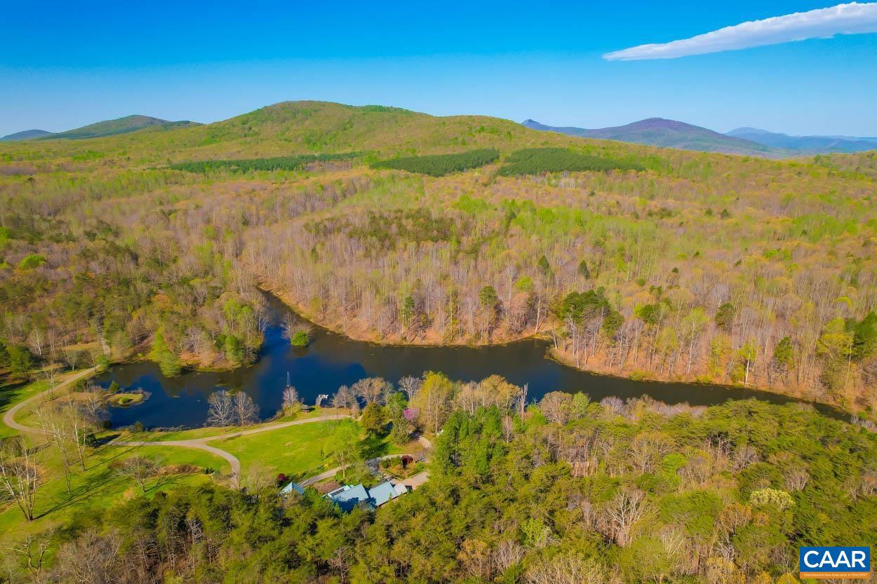 Schuylark presents an exceptional opportunity to own a secluded personal retreat nestled in the picturesque foothills of Central Virginia's serene Blue Ridge Mountains. Serving as the residence to the founders of the neighboring Quarry Gardens at Schuyler, a renowned 40-acre botanical garden, this land has been under the care and stewardship of naturalists and land management professionals for more than two decades. Once owned by the Alberene Soapstone Company, the land features varied topology and fascinating geology. The house sits on a 400-acre parcel that is under conservation and enjoys a panoramic view over the 9-acre lake and up to the mountains. The home has an informal charm, designed for the comfort of its owners as well as for guests and entertaining. Wildlife enthusiasts will appreciate the abundance of deer, black bears, and more than 100 species of birds. With almost a mile of Rockfish River frontage and over 10 miles of well-maintained paths, roads, and trails, Schuylark provides endless opportunities for hiking, hunting, birding, fishing, mountain biking and related naturalist pursuits. Additional unrestricted 140 acre neighboring parcel can be included if desired.,Wood Cabinets,Wood Counter,Fireplace in Family Room,Fireplace in Living Room