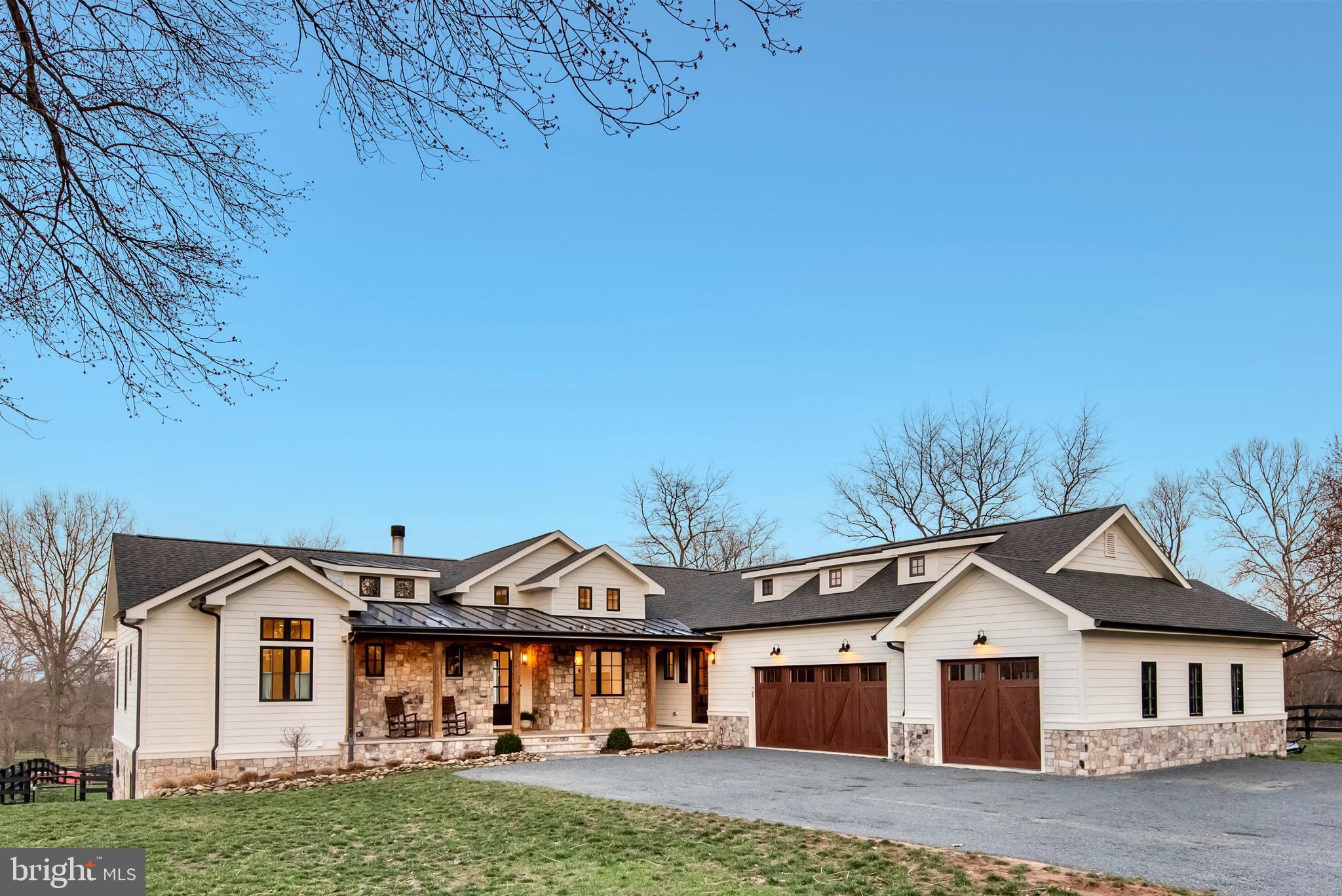 Tucked in the countryside on the edge of historic  Middleburg, this light-filled custom home enjoys the daily breathtaking backdrop of the sunrise over peaceful, pastoral farmland.  With nearly three acres, a fenced dog yard and 3 board fenced paddocks, there is ample space for a pool, a vegetable garden, fruit trees, honey bees, chickens, dogs and other four legged pets; pick your passion. 

Minutes from the center of town, this family retreat enjoys easy access to any number of venues from fine dining, craft breweries, local wineries, farmers markets, sporting art, boutique shopping, the community center, live music, horse racing, polo, foxhunting, yoga, hiking, parks and a welcoming library. There is something for everyone.  

Thoughtfully built and artfully designed by the current owners, a builder/designer couple, as their primary residence, the 5 bedroom, 5.5 bath, two level home embodies comfortable family living and entertaining with luxurious style. 

The covered front porch combines slate, stone and wood and welcomes you into an expansive menagerie of sensual delight. From the cathedral ceiling, antique mantled fireplace with hand patinaed tiles and warm subdued oak wood floors to the modern artful lighting, Eastern wall of Anderson windows, complete with  rolling farmland views and the uber stylish dekton countered kitchen, the home exudes quality, ambiance and comfort. The separate dining area enjoys sunrise views in the morning, long afternoon shadows and starry skies by night.  Alternatively the balcony provides a lovely spot for dining alfresco overlooking the neighboring horse farm and surrounding countryside.  A paneled music room/ den is a gracious spot to relax. 

The main level primary wing is sumptuous with a gracious bedroom, two exceptionally roomy customized walk- in closets and a dreamy spacious spa bathroom with hand finished accents, double vanities, a grand steam shower and soaking tub with a view. 

The main level is further complimented by a half bath, a bright home office and a second bedroom with full bathroom en suite. 
A separate entrance from the covered front porch opens to the herringbone tiled mudroom area with ample storage, a main level laundry room with commercial washer and dryer and dog bath for furry friends.

Downstairs you will find the light filled lower level with 9 ft ceilings, offering a second living room with a gas fireplace, a complete second kitchen with island seating, three large bedrooms with bathrooms and an expansive home gym, or flex use space complete with a wall of storage lockers and easy access to a full bathroom. Additionally, there is a lower level laundry room with a commercial washer and dryer. Walk out to the covered slate patio for lounging and the large fenced yard. An oversized three car attached side loading garage allows space for vehicles and equipment. 

High speed Internet, No HOA, farmland views, minutes to all amenities, 45 minutes to Dulles International airport and 1 hour to DC. Please see virtual tour and list of specialized improvements.

See the 3D tour to experience every detail.  Call to make an appointment to view in person.  Detailed list of amenities in docs. 

https://homevisit.view.property/public/vtour/display/2312296?a=1&pws=1#!/