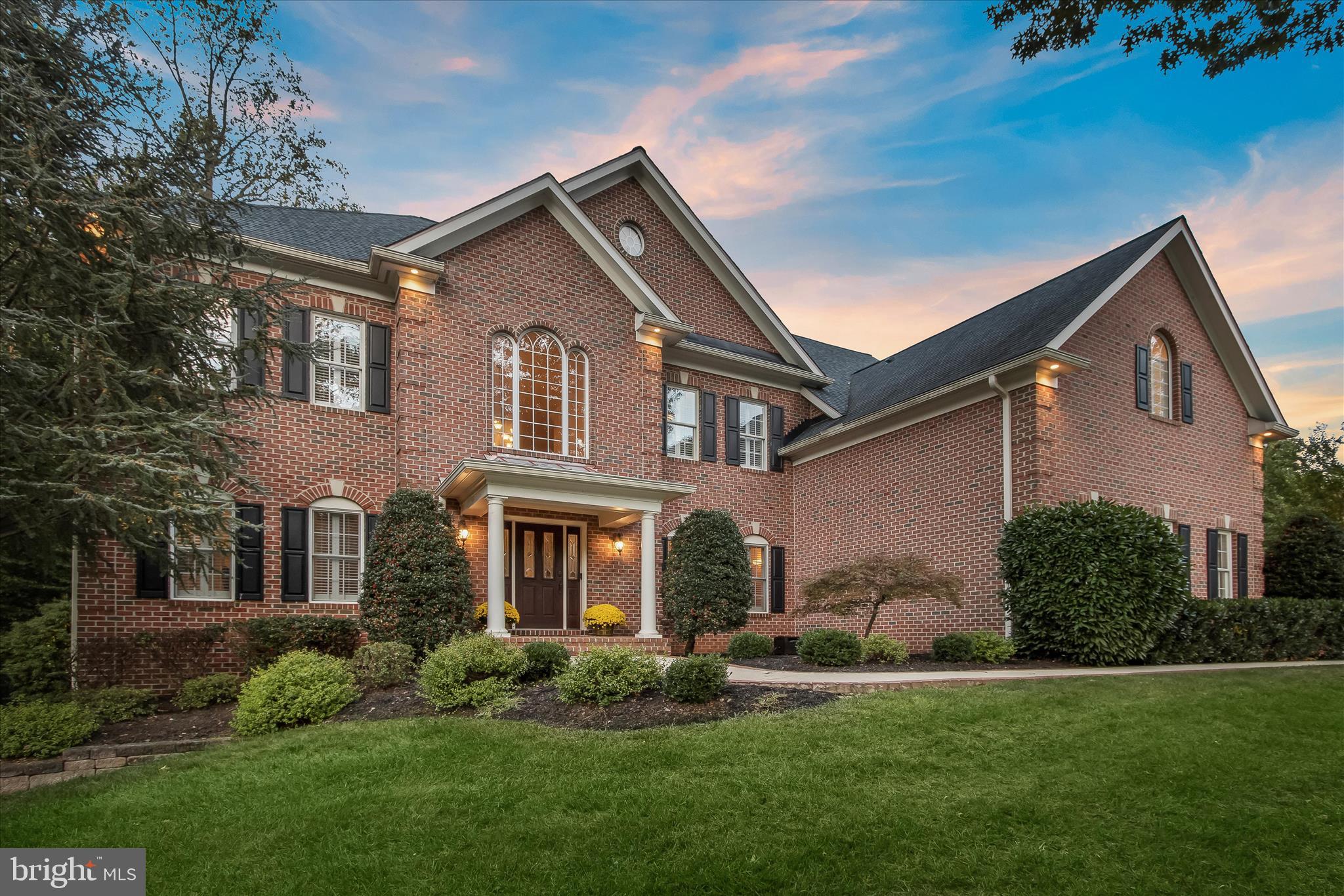 Respectfully requesting all offers by Monday, April 20th by Noon. Stunning all brick estate in Pindell Woods, one of Fulton’s most sought-after communities, set on nearly an acre at a premium corner homesite. Offering over 6,000 square feet across three finished levels, this residence is complemented by a private, retreat-style backyard designed for exceptional outdoor living, featuring an expansive patio and a rustic stone outdoor fireplace. Notable upgrades include a new A/C system, fencing, carpeting throughout, washer and dryer, as well as a whole-home water filtration system.  A sun-filled two-story foyer welcomes you with hardwood flooring and a grand staircase adorned with black iron balusters, framed by wide arched openings to the formal living and dining rooms enhanced with elegant accent molding. The impressive two-story great room showcases a dramatic floor-to-ceiling rustic stone fireplace with an upper overlook and flows seamlessly into the gourmet kitchen. Here, an oversized tiered island, granite countertops, tile backsplash, rich wood cabinetry, and stainless steel appliances, including wall ovens and a beverage cooler, create the perfect setting for entertaining. Glass French doors lead to a private home office, while a spacious laundry room and powder room complete the main level.  Upstairs, the luxurious primary suite offers a tranquil sitting room, dual walk-in closets, and a spa-inspired bath with dual vanities, a soaking tub, and a frameless shower with seating, rainfall, and handheld shower heads. A second bedroom features its own en suite bath, while two additional bedrooms share a third bathroom.  The finished lower level is designed for leisure and lifestyle, featuring a recreation room with a stone fireplace, a four-person wet bar, a dedicated exercise area with mirrors, rubber flooring, and custom lighting.  Step outside to the fully fenced backyard oasis, where an expansive bluestone patio, outdoor fireplace, open play areas, and a serene wooded backdrop provide the ultimate setting for relaxation and gatherings.  Ideally located between Maple Lawn, Columbia, and Clarksville, this exceptional home offers convenient access to abundant shopping, dining, entertainment, and major commuter routes.