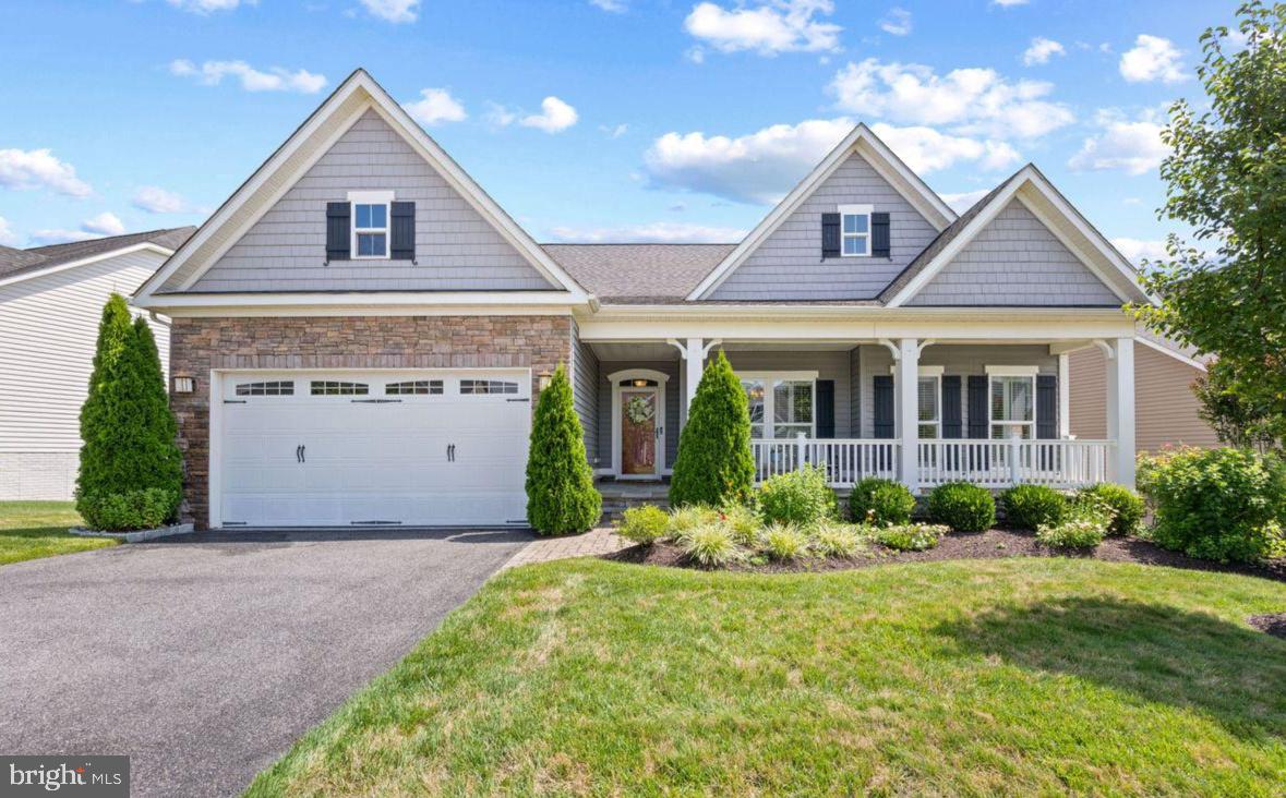 Built in 2016, this detached home showcases a harmonious blend of modern architecture and high-end finishes, ensuring a warm and inviting atmosphere. Step inside to discover a spacious layout that features four generously sized bedrooms and four beautifully appointed bathrooms. The heart of the home is the gourmet kitchen, complete with upgraded countertops, an island for casual dining, and a pantry that caters to all your culinary needs. The combination of the kitchen, dining, and living areas creates an ideal space for entertaining or enjoying quiet evenings at home. Crown moldings and wainscoting add a touch of sophistication, while recessed lighting and ceiling fans enhance the ambiance throughout. The family room, conveniently located off the kitchen, is perfect for gatherings, and the formal dining room provides an elegant setting for special occasions. The gas fireplace is double-sided, both the focal point of the family room and it creates a cozy space on the elevated screened porch. The primary suite is a true retreat, featuring a luxurious bathroom with a walk-in shower, dual sinks with granite vanities, and plenty of walk-in closet space. It also opens directly to the screened porch for peaceful morning routines.  Additional highlights include hardwood and ceramic tile flooring, and a main floor laundry for added convenience. An upper level bedroom with its own bath may also be a useful office or den space. The lower level bedroom and another full bath with walk-in shower offers guests additional privacy. The basement family room includes a bar for entertaining, and the basement French doors open to a lovely paver patio, to continue the party outside. The basement includes generous storage space, with two separate utility rooms also. The property boasts extensive hardscaping and exterior lighting, creating an inviting outdoor space for relaxation or entertaining. Enjoy the lush garden and lawn views from your backyard, perfect for unwinding after a long day. The community amenities are second to none, featuring an outdoor and indoor pool, tennis courts, a clubhouse, and a recreation facility that encourages an active lifestyle. With walking and biking trails, a dog park, and various recreational options, there's always something to do. Parking is a breeze with an attached two-car garage, providing both convenience and security. The community association takes care of common area maintenance, lawn care, and management, allowing you to focus on enjoying your new home and the vibrant lifestyle it offers. This property is not just a home; it's a gateway to a fulfilling and luxurious lifestyle in a welcoming community. Experience the perfect blend of comfort, elegance, and convenience in this exceptional residence.