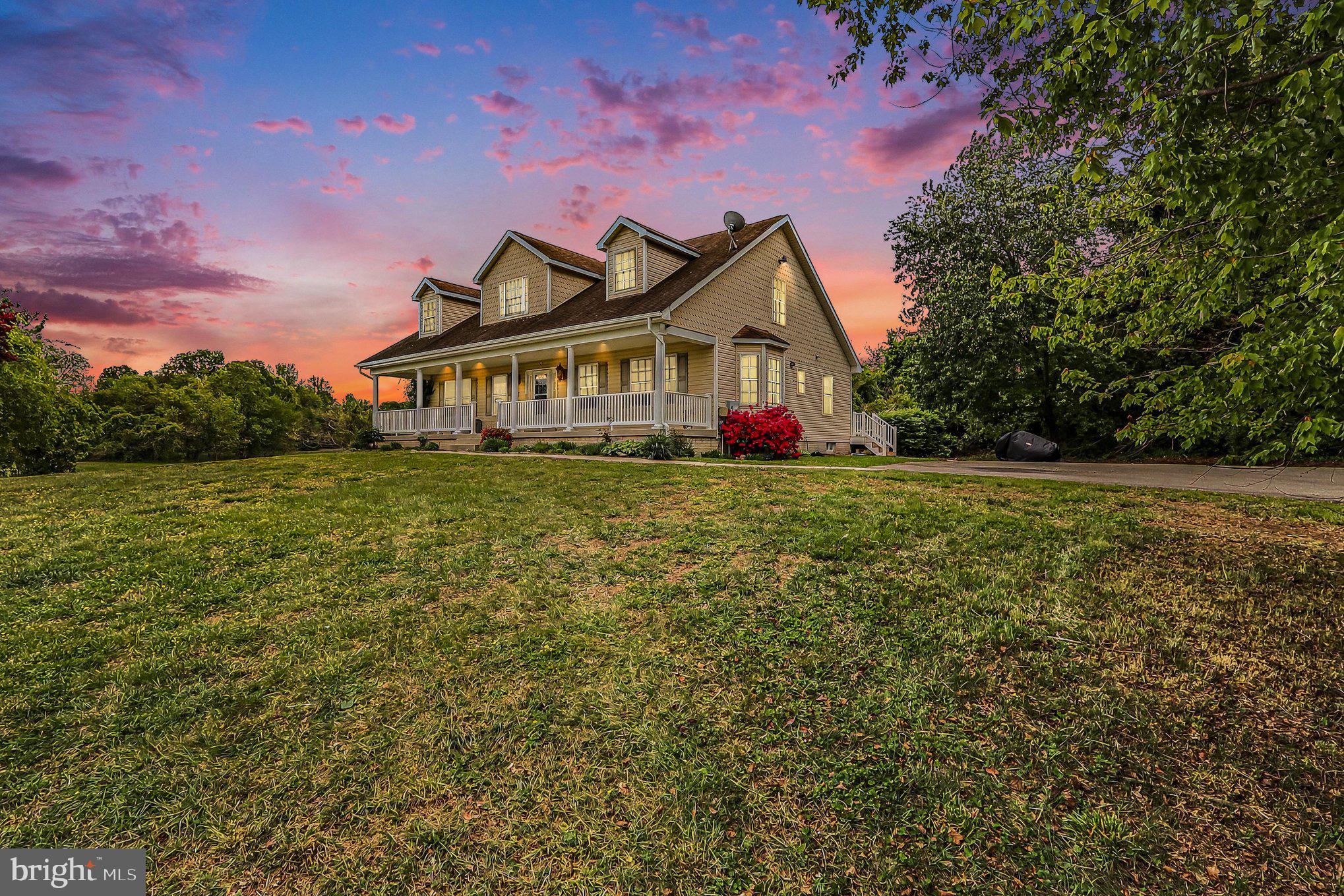 Back on market -- Prior buyer unable to perform; their loss is your gain! Dream big on this expansive property offering just under 7 acres of land, paired with a stately Cape Cod boasting over 4,500 square feet, including 1,800 sq. ft. of unfinished basement space with a rough-in for a 4th full bathroom. Thoughtfully designed for comfort and long-term living, this 4-bedroom, 3.5-bath home features two primary suites on the main level—each with its own ensuite bath—ideal for multigenerational living or aging in place. Upstairs you'll find 2 additional, spacious bedrooms and 1 full bath as well as brand new carpeting. Perched at the highest point of the property, the home welcomes you with a dramatic two-story foyer and warm hardwood floors throughout the main level. The open-concept kitchen and family room create an inviting space for gathering and entertaining, complete with generous cabinet storage and ample counter space for any home chef. Step outside and enjoy your private retreat: a full-width front porch, a rear deck off the family room, and endless potential just beyond the walkout basement—perfect for adding a patio or outdoor living area. A whole house generator gives peace of mind. Imagine the possibilities for the unfinished basement - creating the ultimate recreation room, home theater, fitness studio, game room, workshop, wine cellar, guest suite, home office or a combination of spaces tailored to your needs. With its expansive footprint, this versatile area allows you to customize and significantly expand your home's functional living space to fit your lifestyle now and for years to come. 

The mostly flat acreage allows for a  multitude of outdoor options —whether you envision a small-scale farm, equestrian setup, or sustainable homestead. Wine enthusiasts will enjoy having Two Lions Vineyard as a neighbor. Conveniently located approximately 7 miles from shopping, dining, and everyday essentials. Driveway parking accommodates up to 6 vehicles.
