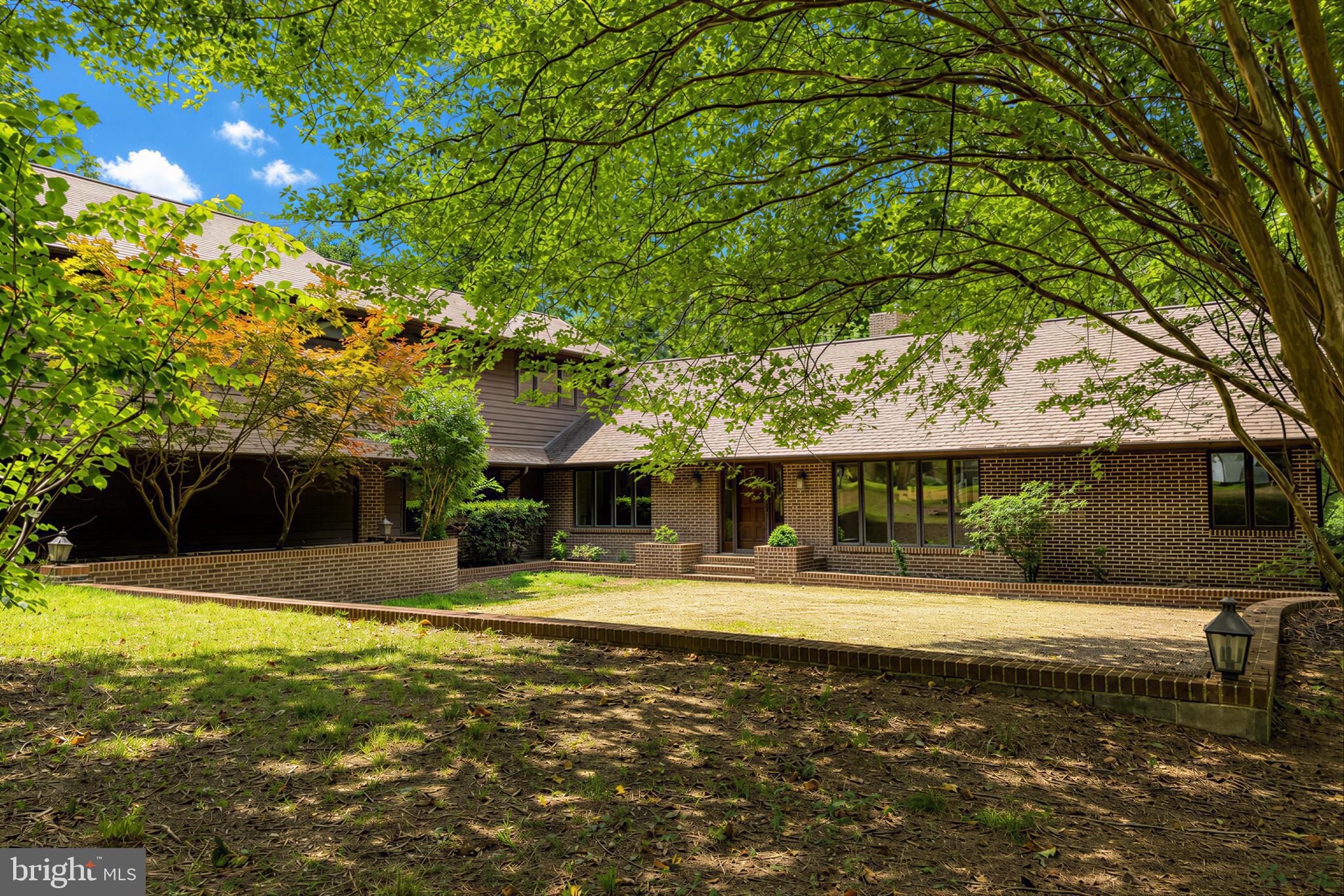 8425 Mausen Lane is a one-of-a-kind custom home tucked privately among the trees, offering a peaceful retreat with exceptional space, architectural character, and endless possibilities. Surrounded by nature and thoughtfully designed with expansive living areas, soaring ceilings, and walls of windows, this home was built to bring the outdoors in while offering the comfort and functionality today’s buyers are searching for. With its flexible layout and multiple private living areas, this home offers exceptional versatility for multigenerational living, entertaining, guests, or everyday living needs.

The dramatic main living area features cathedral ceilings, a stunning floor-to-ceiling brick fireplace, hardwood floors, and an abundance of natural light flowing through oversized windows overlooking the wooded setting. The spacious kitchen opens into the family room, while a separate dedicated dining area, office space, and additional flex areas provide functionality and versatility throughout the home. Two main-level bedrooms each offer private ensuite baths, creating ideal accommodations for family or guests. Multiple side decks extend the living space outdoors and provide the perfect setting for entertaining or simply enjoying the peaceful surroundings.

The lower level continues to impress with an additional bedroom and private bath, a spacious family room, and a bar area that can also function as a second kitchen for extended living arrangements or entertaining. Three additional flex rooms and a half bath offer endless options for guest rooms, fitness space, hobbies, home business needs, or storage. Walkout patios create seamless indoor and outdoor living opportunities.

The impressive addition above the oversized garage offers two additional bedrooms, a beautifully updated full bath with a soaking tub and updated shower, plus an additional flex room perfect for a playroom, office, or private retreat.

The oversized garage is another standout feature, including a large bay with the ability to accommodate boat or RV storage, a rare and valuable feature for buyers needing additional space for recreational vehicles, equipment, or workshop needs.

The seller has invested significantly in preparing the home for its next owner, including professional interior and exterior painting, updated hardwood floors, new carpet throughout, a new roof with transferable warranty, chimney inspection with all recommended repairs completed, new insulation in the original portion of the home, and a septic system that will be county certified.

With no HOA, a private wooded setting, multiple outdoor living spaces, and flexible room configurations rarely found in today’s market, this home offers a unique opportunity for buyers seeking space, privacy, and versatility. Architectural drawings of the home will also be available to help fully appreciate the thoughtful layout and possibilities this exceptional property offers.