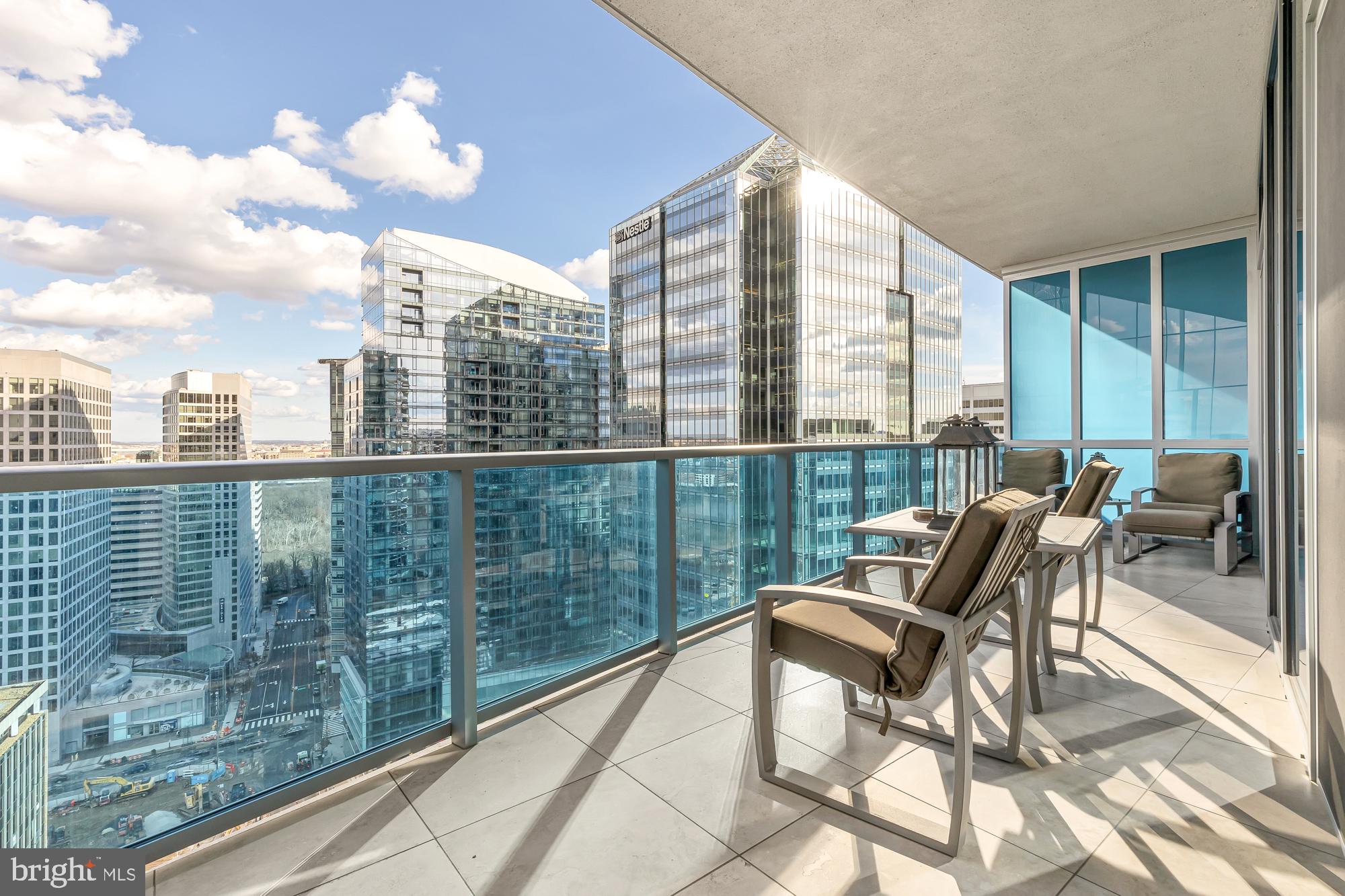 Soaring over the heart of Rosslyn as the Capital Region’s tallest condominium building, Turnberry Tower represents the epitome of white-glove city living. Perched 19 stories high above the vibrant streets below is Unit 1911, a spectacular floor plan featuring 3,050 indoor square feet of ethereal living space, 9-foot ceilings, and sweeping views encompassing the Potomac River, Georgetown Waterfront, and Rosslyn’s glittering urban core. An elegant reception vestibule with private elevator access gives way to a true open floor plan framed by floor-to-ceiling windows with automated shade and drapery systems. A private balcony overlooks downtown Rosslyn, the evening twilight glinting off its skyscrapers’ glass facades. Living and dining areas are fully connected yet distinct, affording an effortless flow when entertaining on a grand scale and complemented by highbrow features such as Lutron lighting, artful storage solutions, raised ceilings, and stacked stone. At the heart of the home is the chef’s kitchen, replete with high-gloss Snaidero Italian cabinetry, natural granite countertops, a full-size SubZero refrigerator, and a suite of Miele appliances including the vaunted built-in espresso machine. Complementing the luxurious finishes are large-form Italian travertine tile floors throughout, establishing a subtle backdrop and augmenting the already copious amounts of natural light flooding into the space. Tucked to one side is the primary suite, rich in appointments with a paneled feature wall and direct terrace access. The ensuite marble-clad bath with its dual vanities, Jacuzzi hydrotherapy tub, and glass shower is equally sumptuous, as are the twin walk-in closets. A secondary bedroom opposite the residence enables total flexibility, featuring spectacular views, a walk-in closet, and a tiled ensuite bath. They are conveniently adjacent to the laundry room, featuring in-unit, full-size Miele appliances. Two assigned underground parking spaces and a private storage unit complete the offering. Being a full-service building, Turnberry Tower conveys all of the ubiquitous personalized amenities, including a 24-hour concierge and security, complimentary valet, a state-of-the-art fitness club with personal trainers, classes, studios, and spa services, an indoor heated swimming pool with hot tub, private cinema, and multiple social rooms for community gatherings. Prominently perched on Rosslyn’s thriving waterfront across the Potomac from Washington’s historic monuments and museums, #1911 at Turnberry Tower is a rare example of uncompromised urban living for the most discerning buyer.