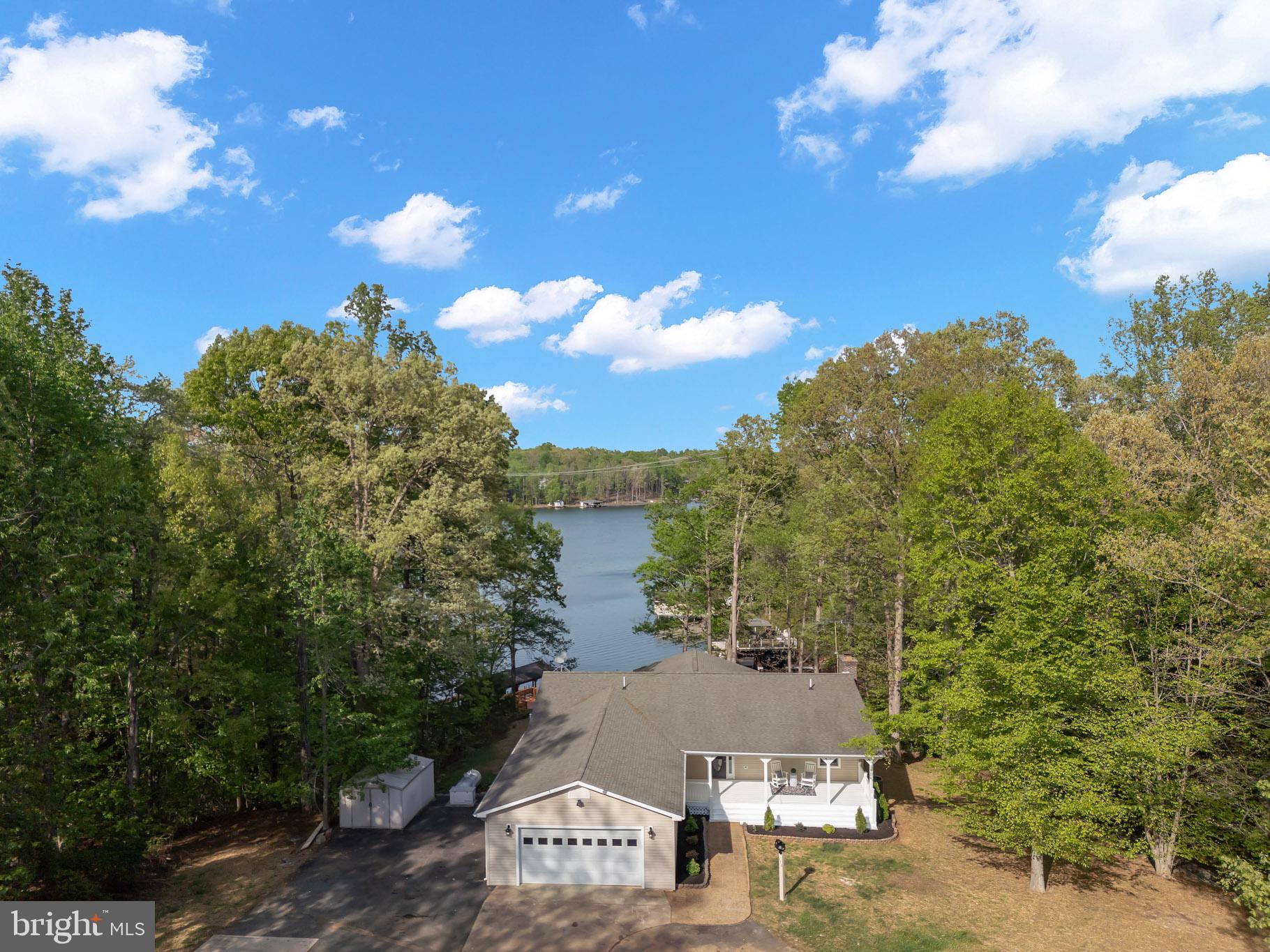 Welcome to your private waterfront escape on the public side of Lake Anna, where deep water, breathtaking views, and exceptional privacy come together in one of the lake's most desirable communities—Tall Pines. Ideally located just south of the Route 208 bridge, this premier location is known for its crystal-clear, deep water and easy access to the main lake while offering the tranquility of a protected cove.  Thoughtfully redesigned from top to bottom, this stunning residence offers more than 3,100 square feet of beautifully updated living space that lives like a custom-built home. The open-concept floor plan was created with entertaining in mind, seamlessly connecting the main living areas while showcasing spectacular lake views from nearly every room. From the welcoming front porch to the multiple lakeside decks and expansive patio, every space invites you to relax, entertain, and embrace waterfront living.  The heart of the home is a beautifully appointed gourmet kitchen featuring custom cabinetry, quartz countertops, premium appliances, and an oversized island that overlooks the water—making it the perfect gathering place for family and friends. Two of the three main-level bedrooms enjoy private deck access and peaceful lake views, while the sunroom provides a front-row seat to spectacular sunrises and year-round waterfront scenery.  The finished walkout lower level offers endless possibilities with a spacious recreation room, cozy fireplace, custom bar, and abundant space for entertaining, game nights, or hosting weekend guests.  Step outside to approximately 153 feet of shoreline and experience some of the best water conditions Lake Anna has to offer. The private cove offers approximately six feet of water at the right side of the dock and quickly deepens to over 12 feet, providing outstanding boating, swimming, and year-round lake enjoyment. The two-slip boathouse features one covered slip with an electric lift plus an additional wet slip, making it easy to accommodate multiple watercraft and spend more time on the lake.

Car collectors, boating enthusiasts, and hobbyists will appreciate the impressive 32' x 35' heated detached garage complete with a half bath (conveys as-is) and an electric vehicle lift, in addition to the oversized attached two-car garage.  Additional features include a whole-house generator for peace of mind, a roof approximately eight years old, and a water heater replaced approximately two years ago. Glass shower enclosures are currently being installed, further enhancing the home's beautifully updated bathrooms.  Offering deep water, extensive renovations, incredible garage space, and one of Lake Anna's most sought-after locations, this exceptional waterfront property is ready for you to begin making memories from the moment you arrive.  Just move in, all set!