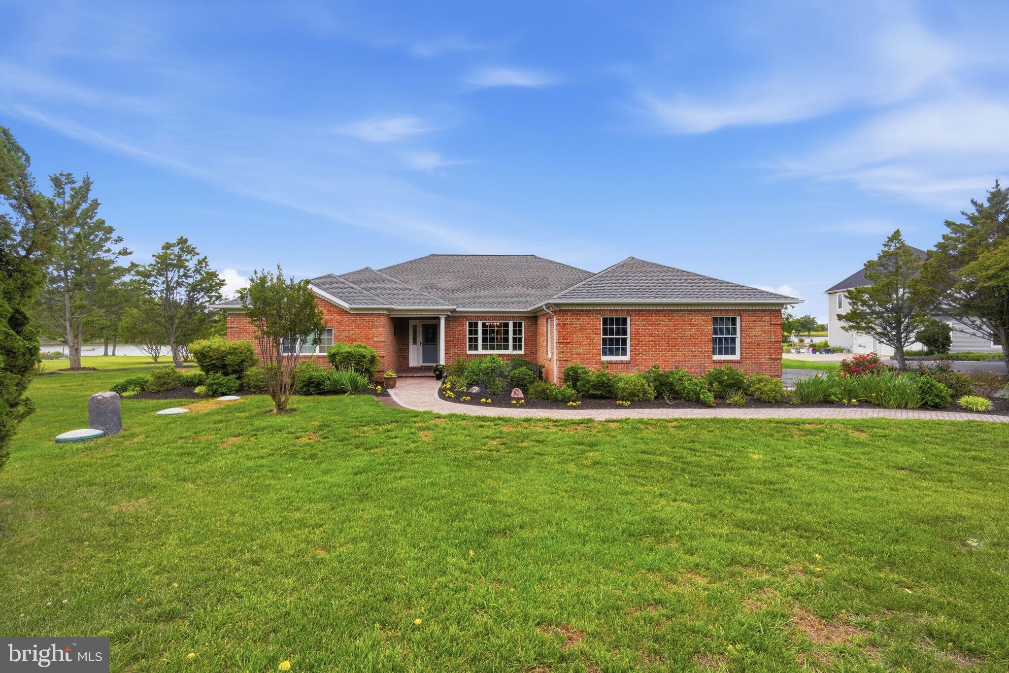 A Peaceful Waterfront Retreat
Set along the quiet shores of Northwest Creek, this beautifully maintained single-story brick home offers sweeping 180-degree water views and a sense of calm from the moment you arrive. The back deck offers an escape to bird watch for eagles, osprey, blue heron, egrets and more during the day and stargaze at night. A gently winding walkway leads through lush, thoughtfully landscaped gardens filled with colorful blooms throughout the year.

A Warm Welcome
Step inside the foyer and the view immediately takes center stage. Straight ahead, past the living room is the sunlit three-season room. The sparkling water creates a stunning backdrop that draws you through the home.

Living Areas & Kitchen
The formal dining room and spacious living area feature warm wood floors, large windows, and plenty of natural light, all designed to showcase the peaceful waterfront setting.

The kitchen is both functional and inviting, with upgraded appliances, Corian countertops, under-cabinet lighting, a tile backsplash, and generous cabinet space. Whether preparing meals or enjoying your morning coffee, the uninterrupted creek views make this space especially enjoyable.

Private Bedroom Layout
The split-bedroom floor plan provides privacy and comfort for both owners and guests.

The primary suite is tucked away on the left side of the home and offers beautiful water views through oversized windows, along with rich wood flooring and a relaxing atmosphere. The spacious en-suite bath includes dual vanities, two walk-in closets, a walk-in shower, and a soaking tub.

On the opposite side of the home, a separate hallway leads to two spacious guest bedrooms filled with natural light, a full guest bathroom with a shower, a convenient half bath and laundry room, and direct access to the oversized two-car garage.

Additional Living Space
Just beyond the kitchen, the home opens into a cozy den and library area. Built-in bookcases and a gas fireplace create the perfect setting for relaxing evenings, reading, or gathering with family and friends.

The Three-Season Room
French doors off the kitchen, Living room, or primary bed room lead into a large three-season room stretching across the back of the home. This room has both heat and a/c provided by a mini split. Surrounded by natural light and panoramic water views, this versatile space is ideal for morning coffee, casual dining, yoga, entertaining, or simply enjoying the peaceful scenery year-round.

The roof was replaced in 2024 with 50 Year architectural shingles, and a transferrable warranty.

Blending indoor comfort with the beauty of the outdoors, this waterfront home offers a quiet retreat designed for everyday living and relaxing.

This home is close to many recreational amenities including parks, with bike trails, pickleball courts, fishing piers and a public golf course.