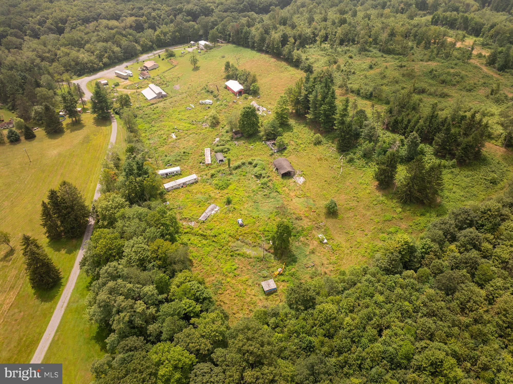 Discover the perfect blend of open space and wooded privacy on this 7.61-acre parcel. Offering a mix of gently rolling fields and mature trees, this property provides endless possibilities—whether you’re looking to build your dream home, create a private retreat, or establish a hobby farm. Several outbuildings are included and being sold “as is”, adding potential for storage, workshops, or creative repurposing. Enjoy the peaceful rural setting while still being within easy reach of local conveniences. This is a rare opportunity to own a versatile piece of land with both beauty and potential.
