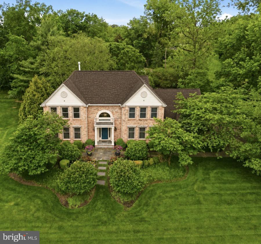 From the moment you step into the soaring two-story foyer, it’s clear this home was designed for both grand entertaining and effortless daily living. Rich hardwood floors guide you through a sophisticated main level where timeless details, like French pocket doors and elegant moldings, set a refined tone. The living room serves as a quiet retreat, featuring custom built-ins that flank an electric fireplace with a handsome wood mantle. Across the hall, the formal dining room offers a stately setting for large gatherings, leading directly into a chef’s kitchen that redefines modern luxury. Anchored by a massive island with leathered granite countertops, this culinary masterpiece is equipped with a Thermador double oven, a custom side-by-side refrigerator and freezer, and a cozy coffee nook perfect for slow mornings. A wall of windows and sliders floods the space with natural light, blurring the lines between the interior and the lush grounds outside. For the ultimate host, the adjacent bar area is a model of convenience, complete with beverage drawers, a prep sink, and a second dishwasher. This hub flows seamlessly into the family room, where integrated surround sound and direct backyard access create an organic indoor-outdoor lifestyle.  Practicality meets polish in the oversized mudroom and laundry suite, which features side-door access to the expanded driveway and entry to the three-car garage, finished with sleek epoxy flooring. Upstairs, the primary suite is a true sanctuary. Raised ceilings with ambient under-lighting and the ease of electric blinds create an atmosphere of pure tranquility. The suite boasts two custom walk-in closets—one featuring a dedicated dressing and makeup vanity—and a spa-inspired bath that rivals a five-star resort, complete with a jetted tub, rain shower, and a rejuvenating steam shower. Three additional bright bedrooms share a beautifully renovated hall bath with a double vanity and contemporary finishes. The living space extends to an incredible finished basement accessed via an elegant French door. Featuring a full kitchen, private office, and a full bath, this level offers the perfect footprint for an in-law suite, guest quarters, or a sophisticated media hub. Outside, the slate patio was thoughtfully designed for accessibility and features a built-in gas grill, ideal for summer evenings under the stars. The expansive, professionally landscaped backyard provides total serenity. With a full-house generator for peace of mind and a location that places you minutes from Germantown Academy, the award-winning Wissahickon School District, and the vibrant dining scene of downtown Ambler, this is more than just a residence—it is a meticulously curated lifestyle.