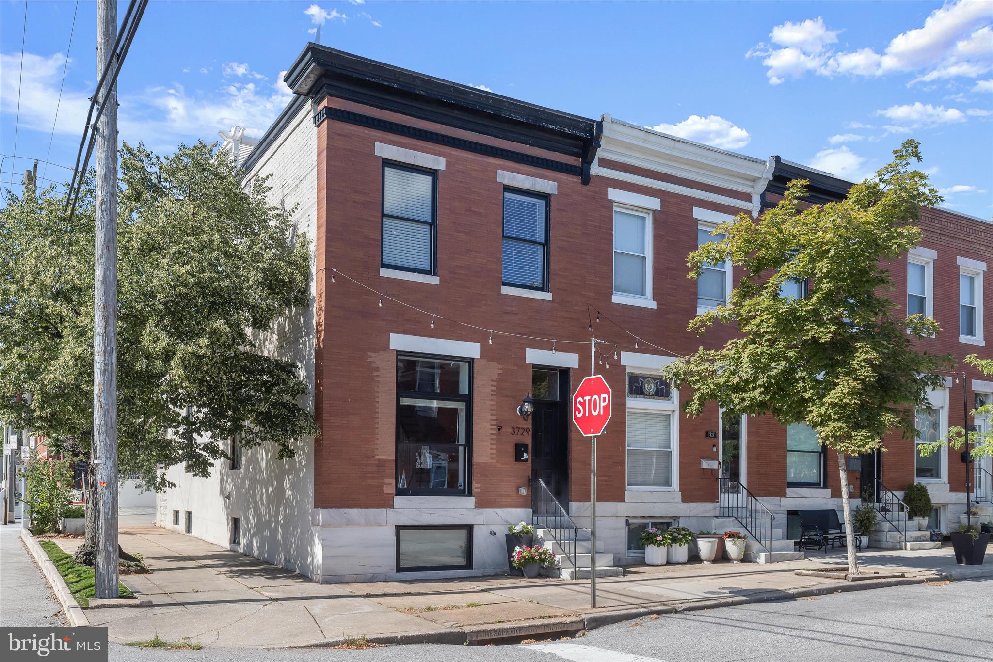 Welcome to this beautifully renovated end-of-group rowhome in the heart of the highly sought-after Brewers Hill, where timeless charm meets modern luxury. Offering 4 bedrooms, 3 full baths, three fully finished levels, and a RARE side-by-side two-car parking pad, this move-in-ready home checks every box.
Step inside to discover gleaming hardwood floors, exposed brick, elegant crown molding, and a stunning coffered ceiling that perfectly complements the home’s original architectural character. The open-concept main level is designed for both everyday living and entertaining, featuring a chef’s kitchen with granite countertops, stainless steel appliances, gas cooking, whisper-glide cabinetry, a massive center island, and seamless flow into the dining and living spaces. Whole-home audio adds an extra touch of luxury throughout. Upstairs, retreat to a spa-inspired owner’s suite highlighted by a bay window and a breathtaking bath featuring a double granite vanity, modern freestanding soaking tub, and designer finishes. An additional bedroom, second full bath, convenient laundry area, and access to the outdoor living spaces complete the upper level. Outdoor entertaining is taken to the next level with a spacious rear deck and an incredible rooftop deck complete with a picturesque pergola and sweeping city views, the perfect setting for morning coffee, evening cocktails, or watching fireworks over Baltimore. The finished lower level provides two generously sized bedrooms and a third full bath, offering endless flexibility for guests, a home office, gym, or media room. Combining luxury finishes, abundant living space, and one of the most coveted features in the city, a comfortable side-by-side two-car parking pad, with a storage shed, this exceptional Brewers Hill home offers the very best of Baltimore living, just moments from Canton, Patterson Park, dining, shopping, and major commuter routes.