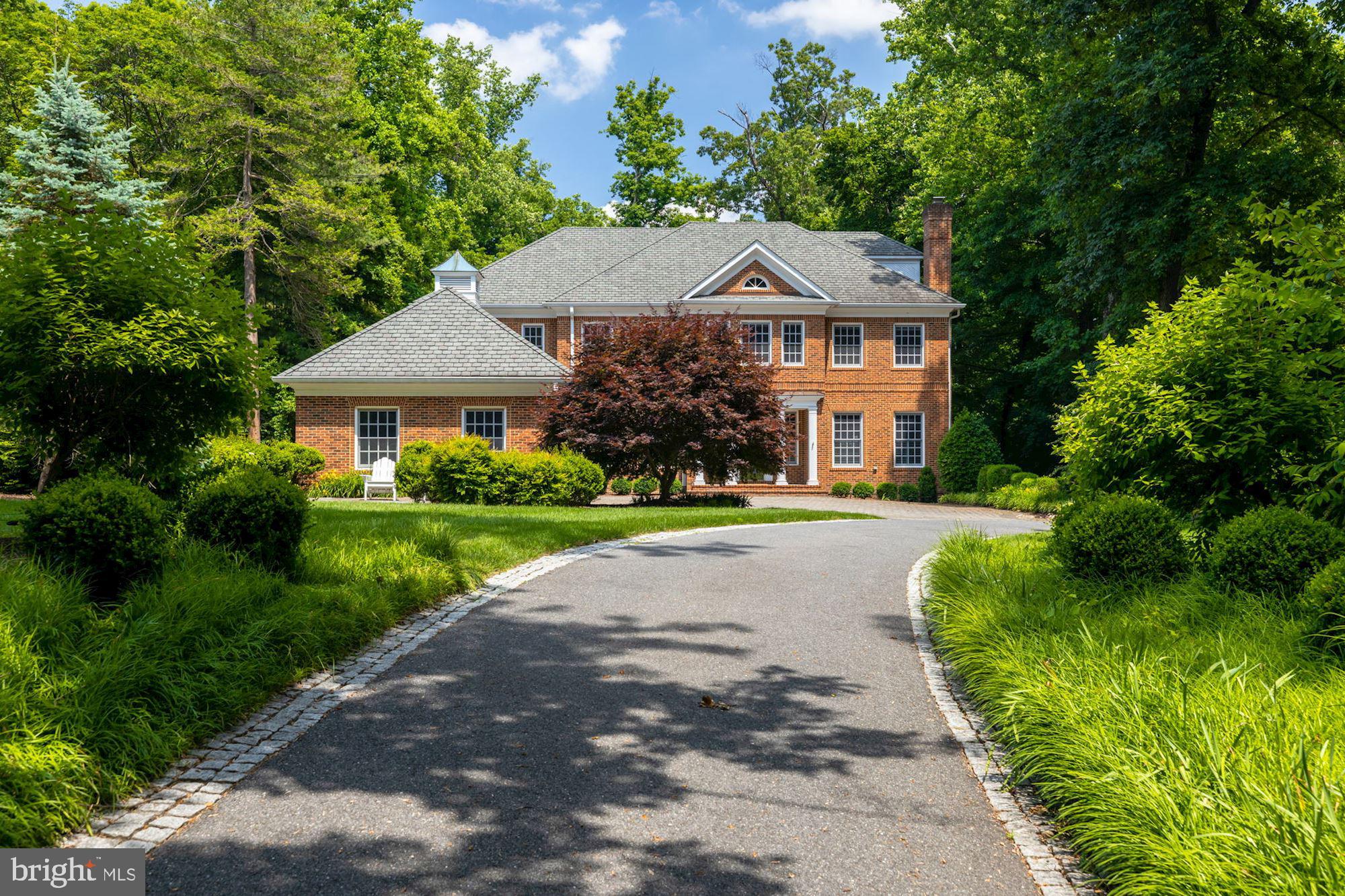 Stately 6  Bedroom 5 Full and 2 1/2 Bath brick Colonial beautifully sited on  expansive  lush private landscaped grounds offering a rarely available  opportunity for privacy, comfortable family living and gracious entertaining on .65 acres.    Approximately 6,800 sq ft of beautifully designed and freshly renovated living space with impressive features and exceptional finishes  on four finished floors.   Showcasing 10' ceilings,  hardwood floors, recessed lights, top of the line appliances and exceptional millwork throughout.   The generous proportions and welcoming floor plan with  sunlight throughout  provides a seamless flow  for the entire family.   Interior design done by Marika Meyer.   Enter into a grand Foyer with gorgeous open staircase, gracious Living Room,  delightful formal Dining Room, and stunning Family Room with fireplace and views of and access to the exterior terraces and gorgeous views of the perfectly landscaped grounds.  The first floor also features a spacious Home Office with custom built-ins, Powder Room, glistening modern gourmet Kitchen with center island for casual dining and sunny Breakfast Room, and walk-in Pantry.   Upstairs offers an expansive bright Primary Suite with fireplace, his/her Bathrooms connected by an oversized walk-in double shower,  several walk-in closets with custom built-ins,  and a generously sized second Office/Sitting Room with custom built-ins. The second floor also features three additional spacious Bedrooms, 2 connected by a Jack and Jill Bath and the fourth with en suite Bath, all with walk-in closets and custom built-ins.  This level  is completed by a sunny Landing area perfect for relaxing on the sofa and reading a book off the built-in bookshelves.   The third floor features an oversized Bedroom and en suite Full Bath with beautiful views of the trees.  Skylight.  The Lower Level with walk-out access to the back yard features another large Family Room with fireplace, a Powder Room, another  Bedroom and en suite Full Bath, fully outfitted home Gym, Wine Closet, Laundry Room, enormous storage and separate utility room.  Views throughout the house of the breathtaking lush private grounds measuring 0.65 acre!!   All within minutes  of the Metro and the wonderful dining and shopping that Bethesda has to offer.  Truly a special home!